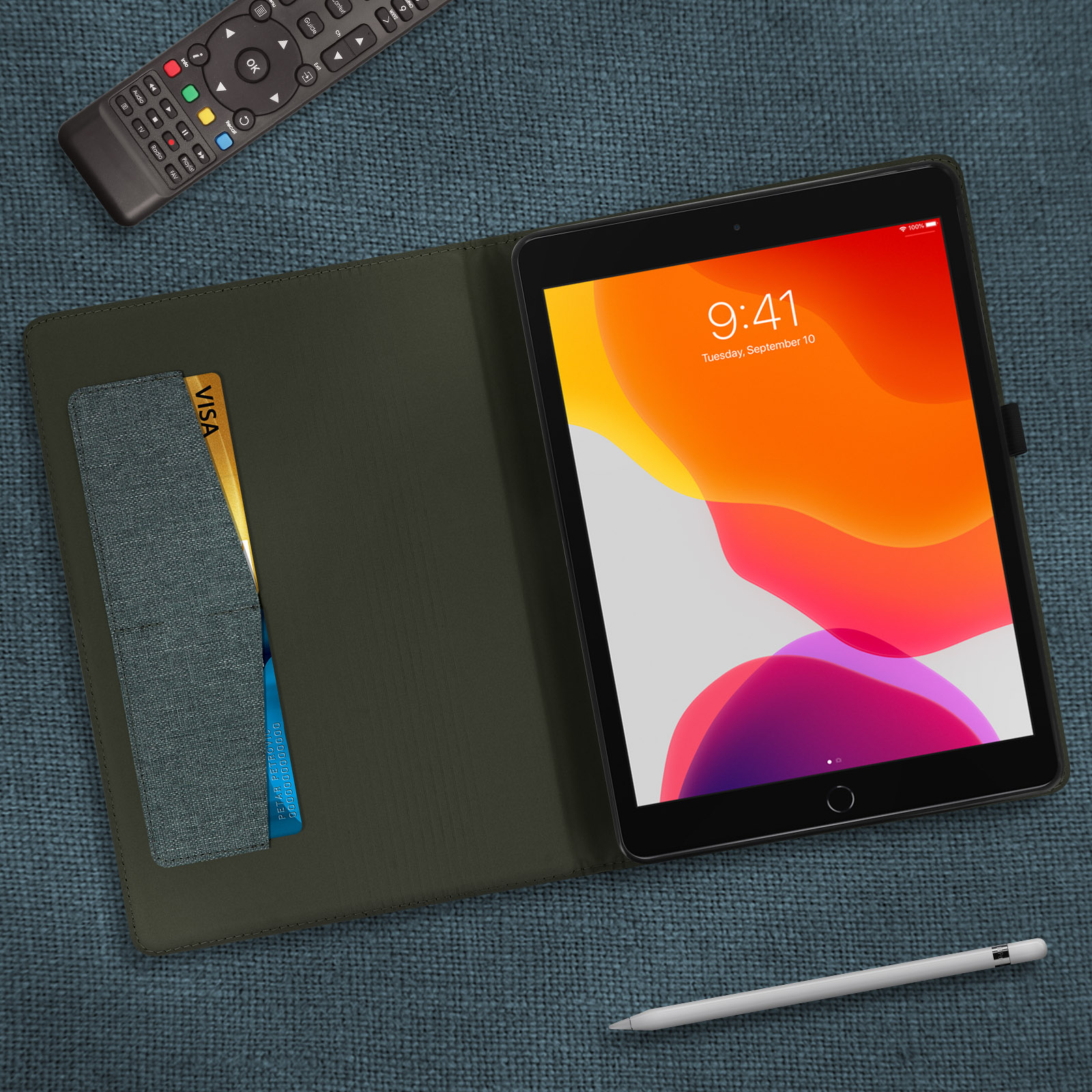 Una custodia per tablet verde scuro aperta con un tablet all'interno. Una carta è nella tasca, una penna è di lato.