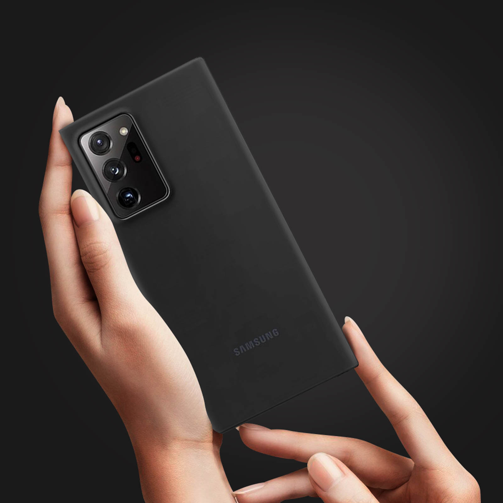 Un telefono nero tenuto in mano, che mostra la fotocamera e la superficie posteriore. Sfondo scuro.