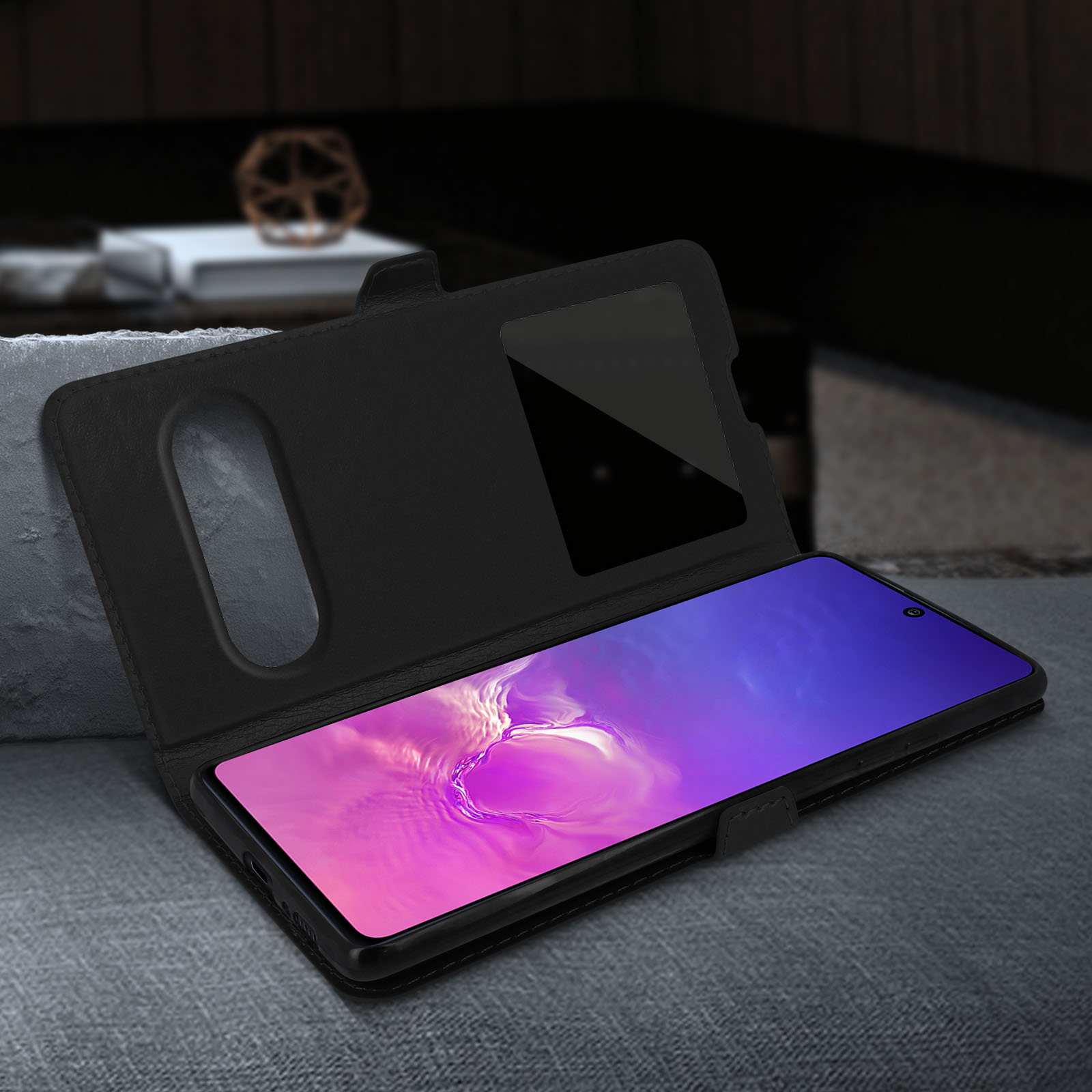 Coque de téléphone noire avec une fenêtre transparente pour voir l'écran. Le téléphone est posé sur une surface grise.