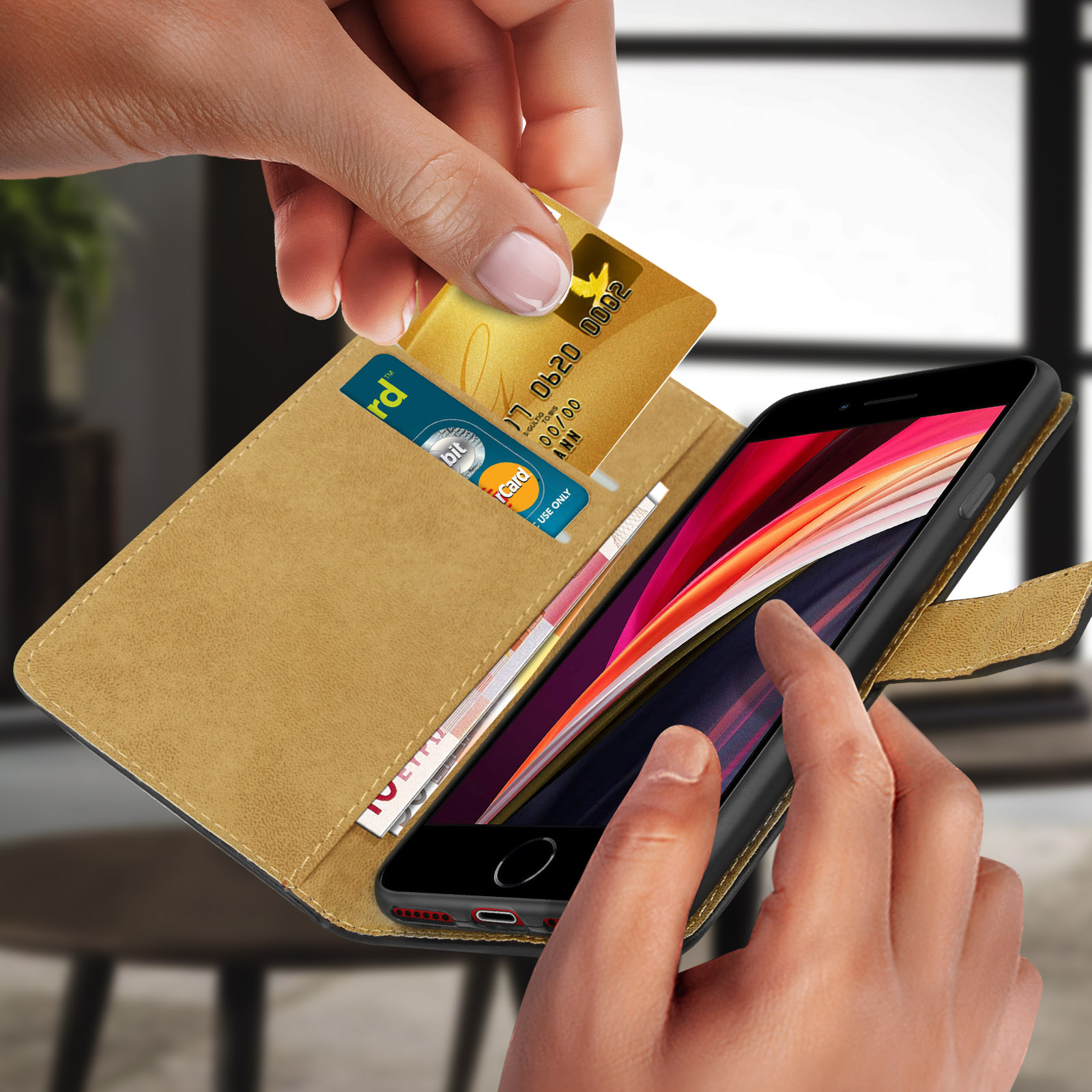 Mano che inserisce una carta di credito dorata in una custodia per telefono. Un'altra carta e contanti all'interno.