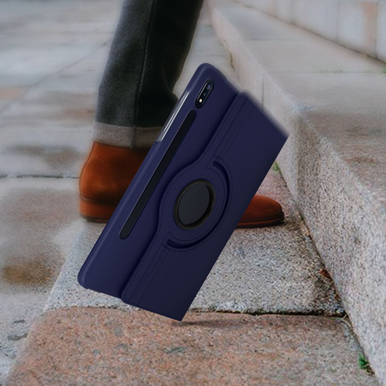 Custodia per tablet con anello rotante, posta su gradini, davanti a scarpe marroni. Custodia blu.