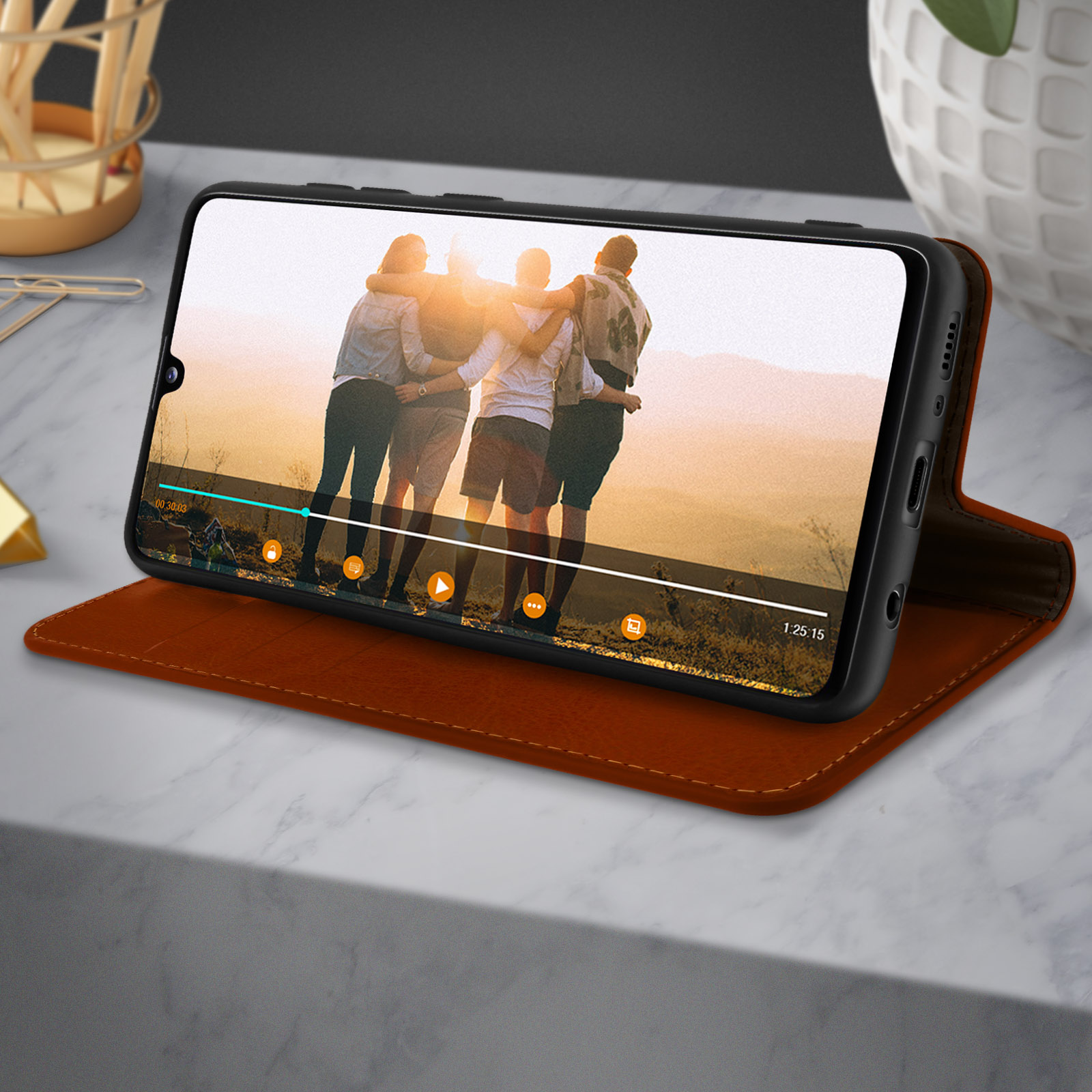 Un smartphone sur un bureau montrant une vidéo de personnes s'embrassant.