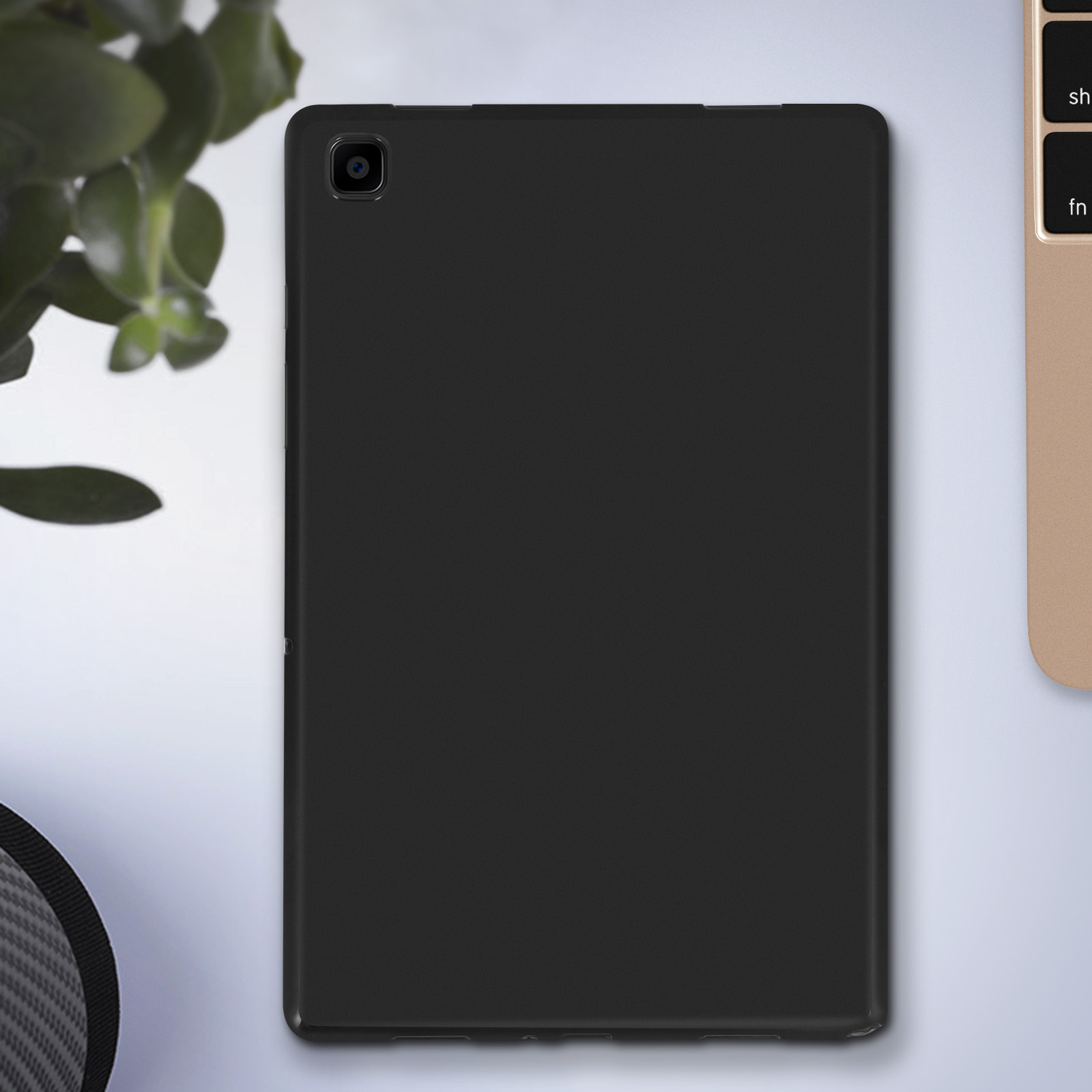 Schwarzes Tablet mit Kamera hinten, Pflanze und Laptop im Hintergrund.