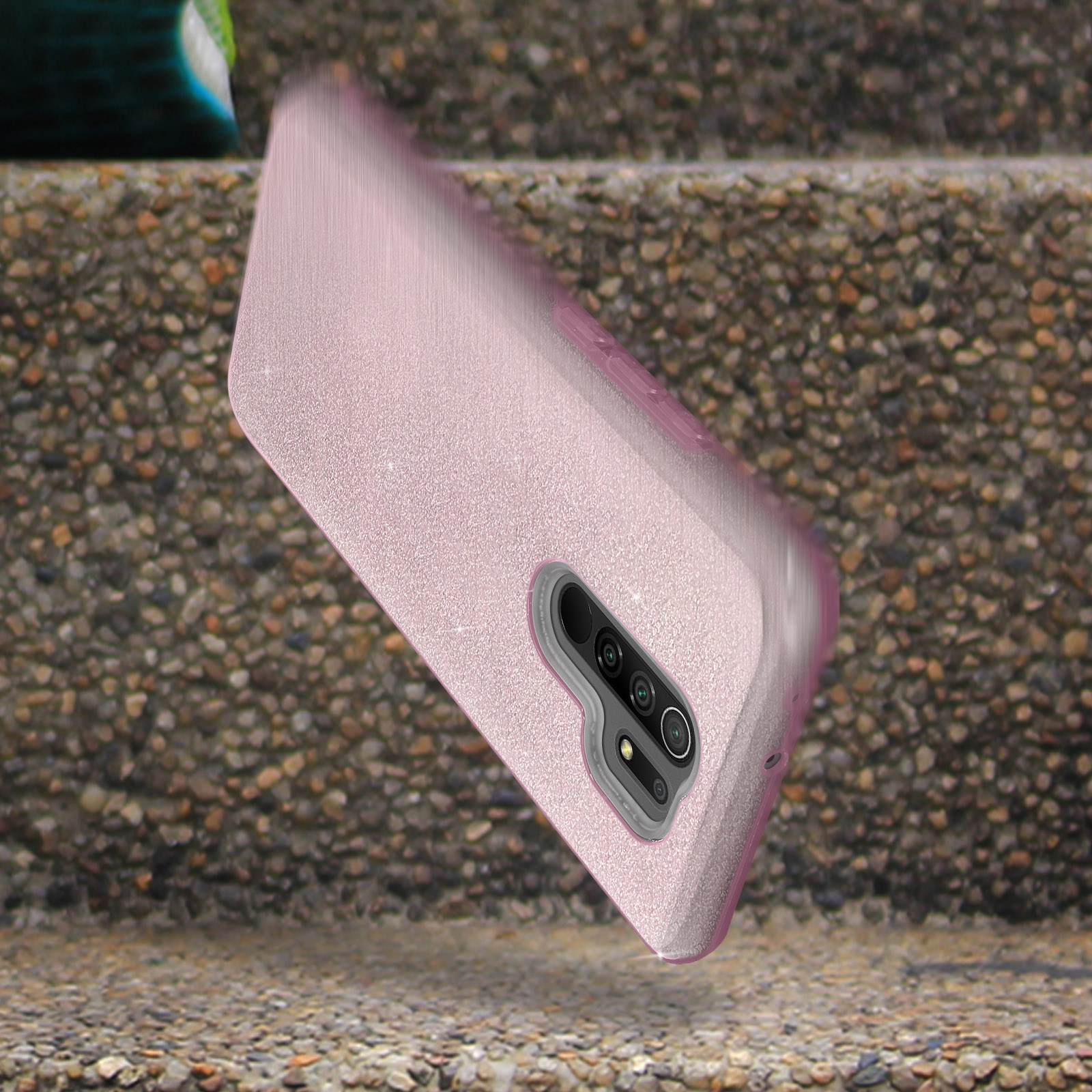Een roze telefoonhoes die op een stenen oppervlak valt, met details van de camera en flitser.