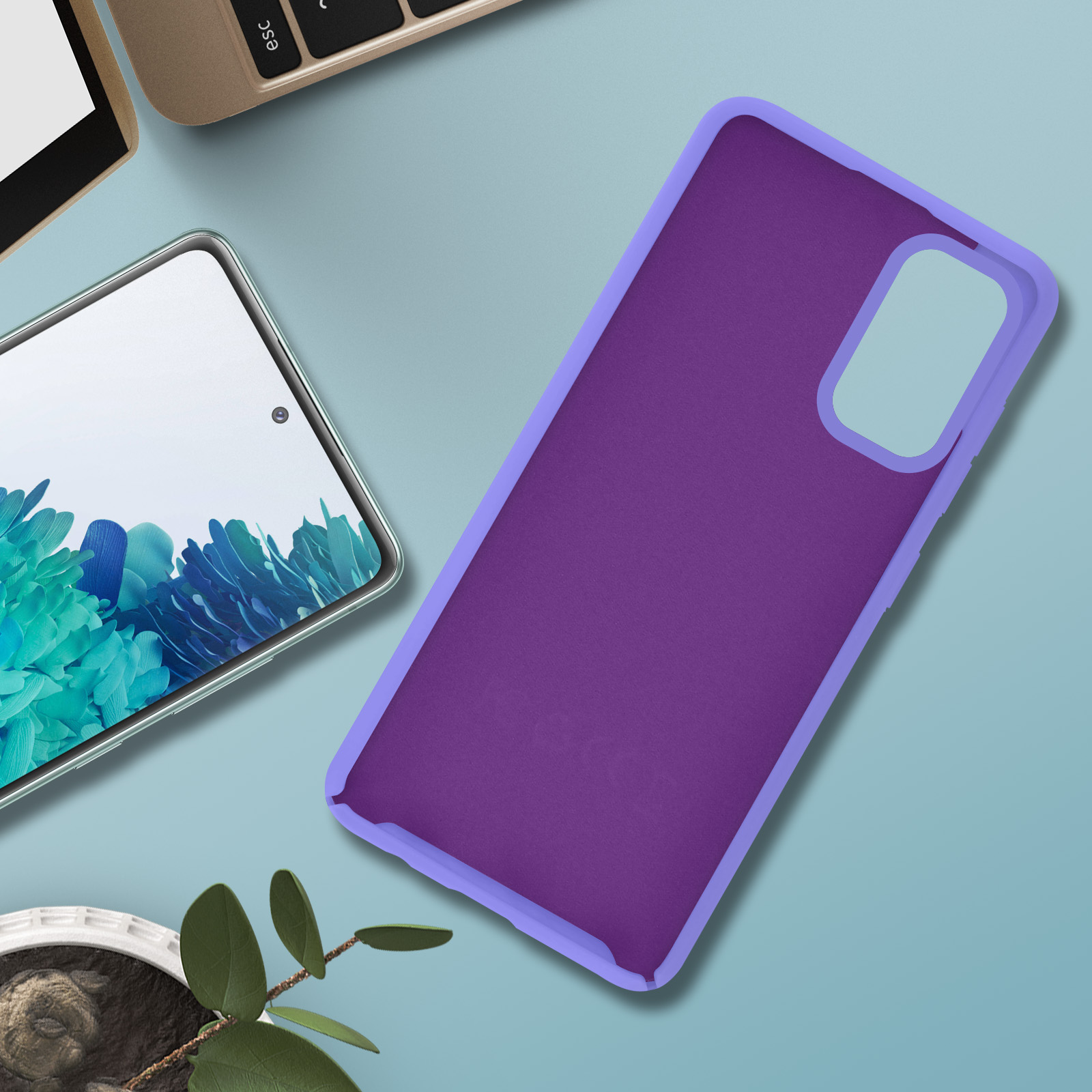 Een paarse telefoonhoes met een blauwe omtrek, naast een telefoon. Een plant staat in de hoek.
