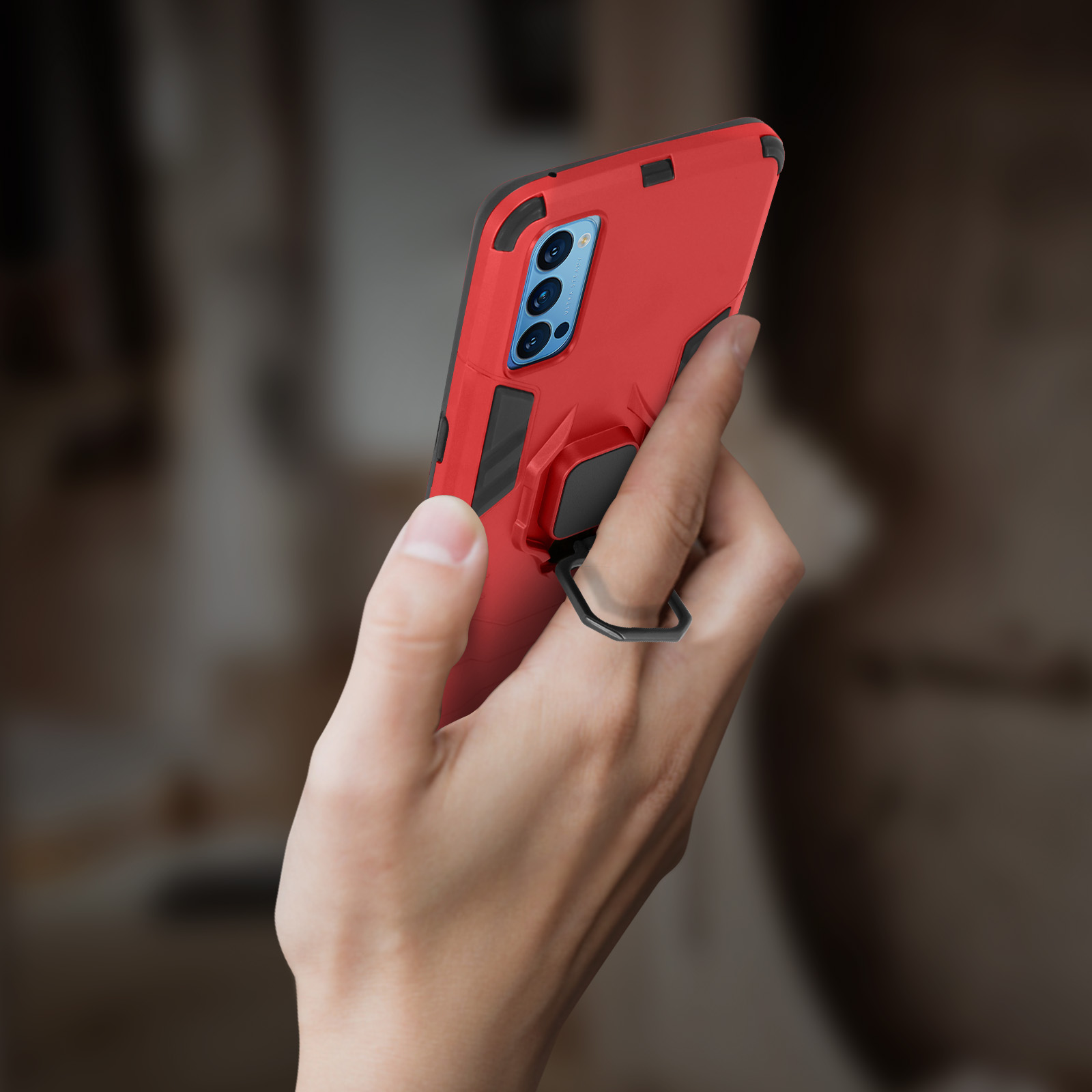 Mano che tiene custodia rossa con anello. Sfondo sfocato.