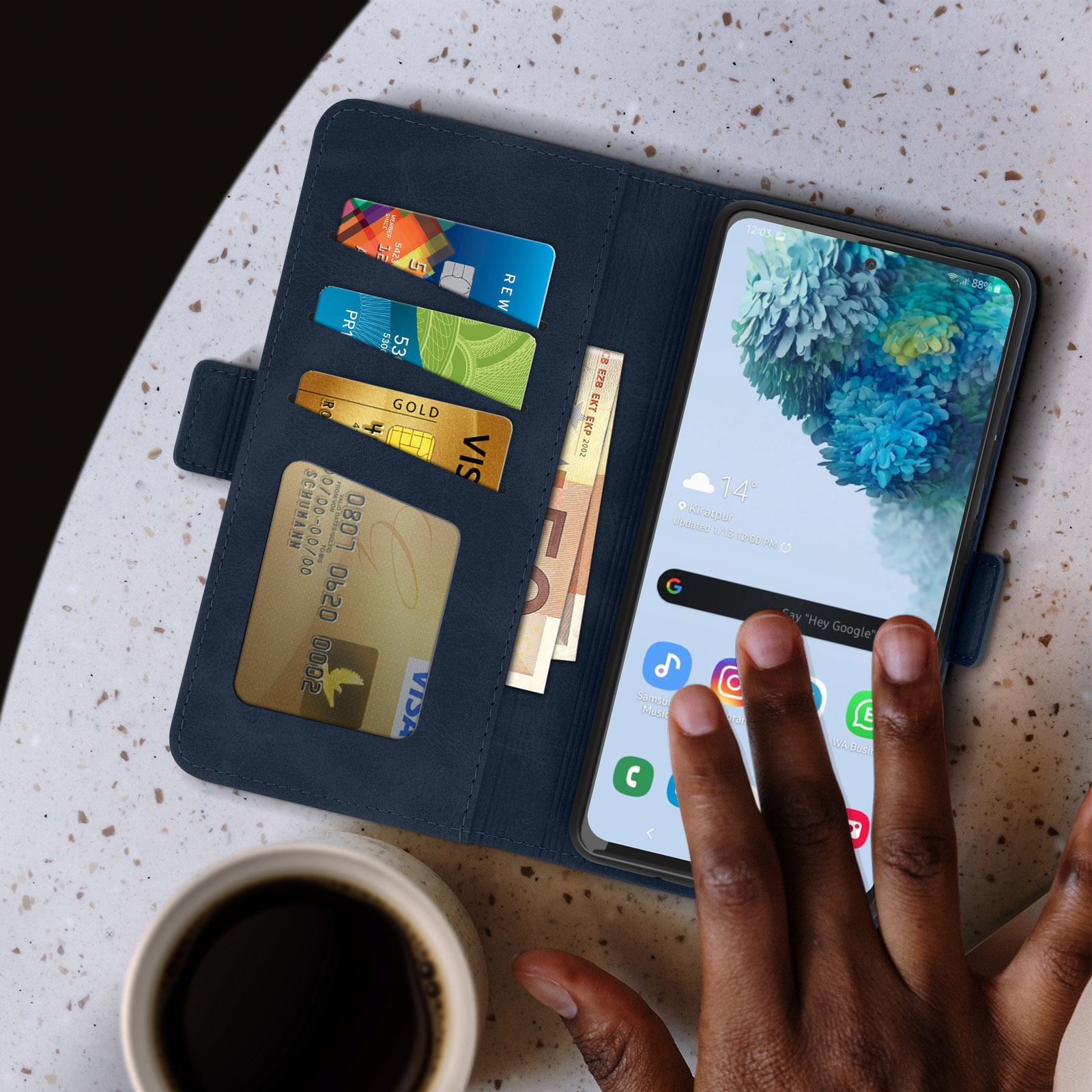 Téléphone dans un étui portefeuille bleu avec cartes, espèces et une tasse de café sur une table.