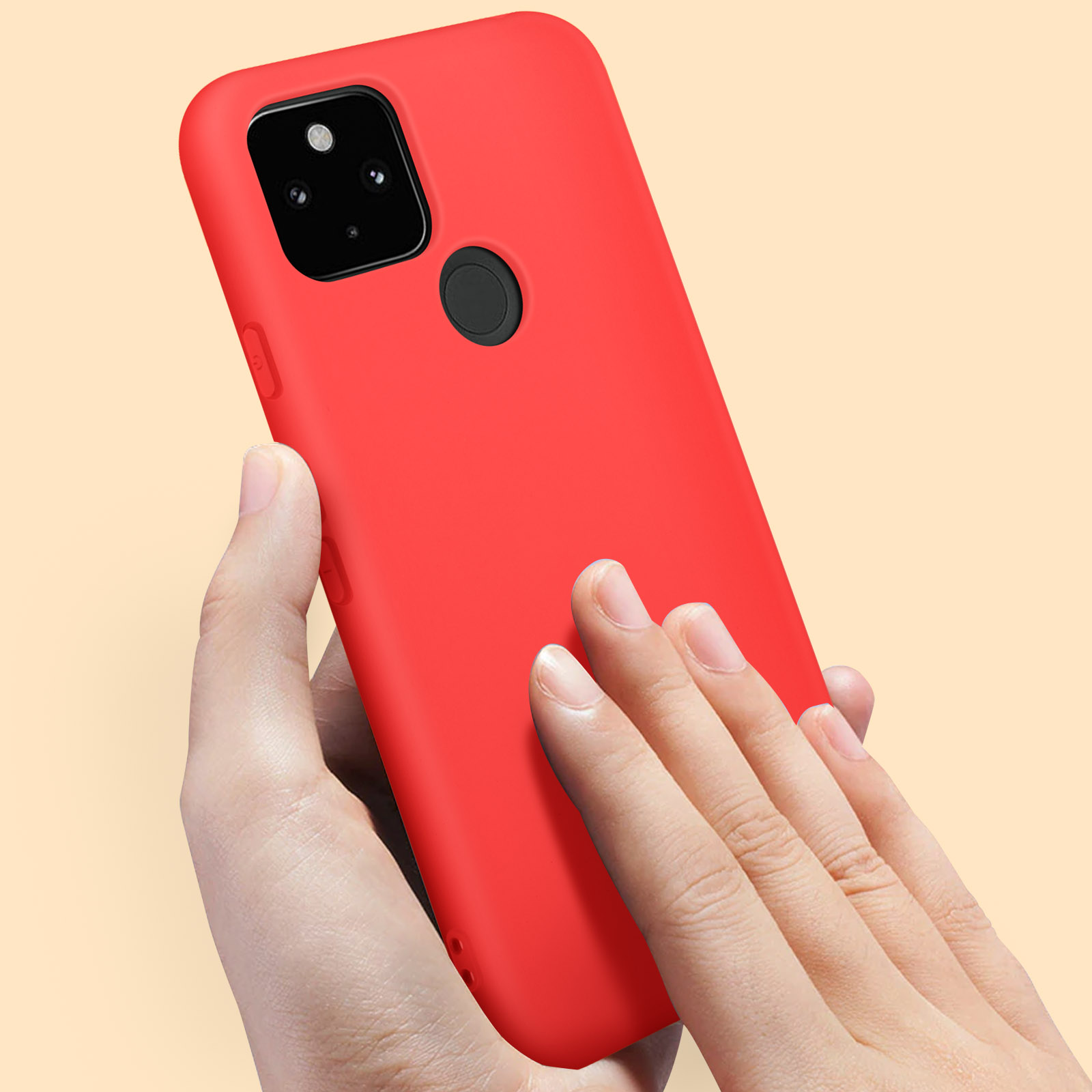 Une personne tient une coque de téléphone rouge. Le fond est de couleur pêche.