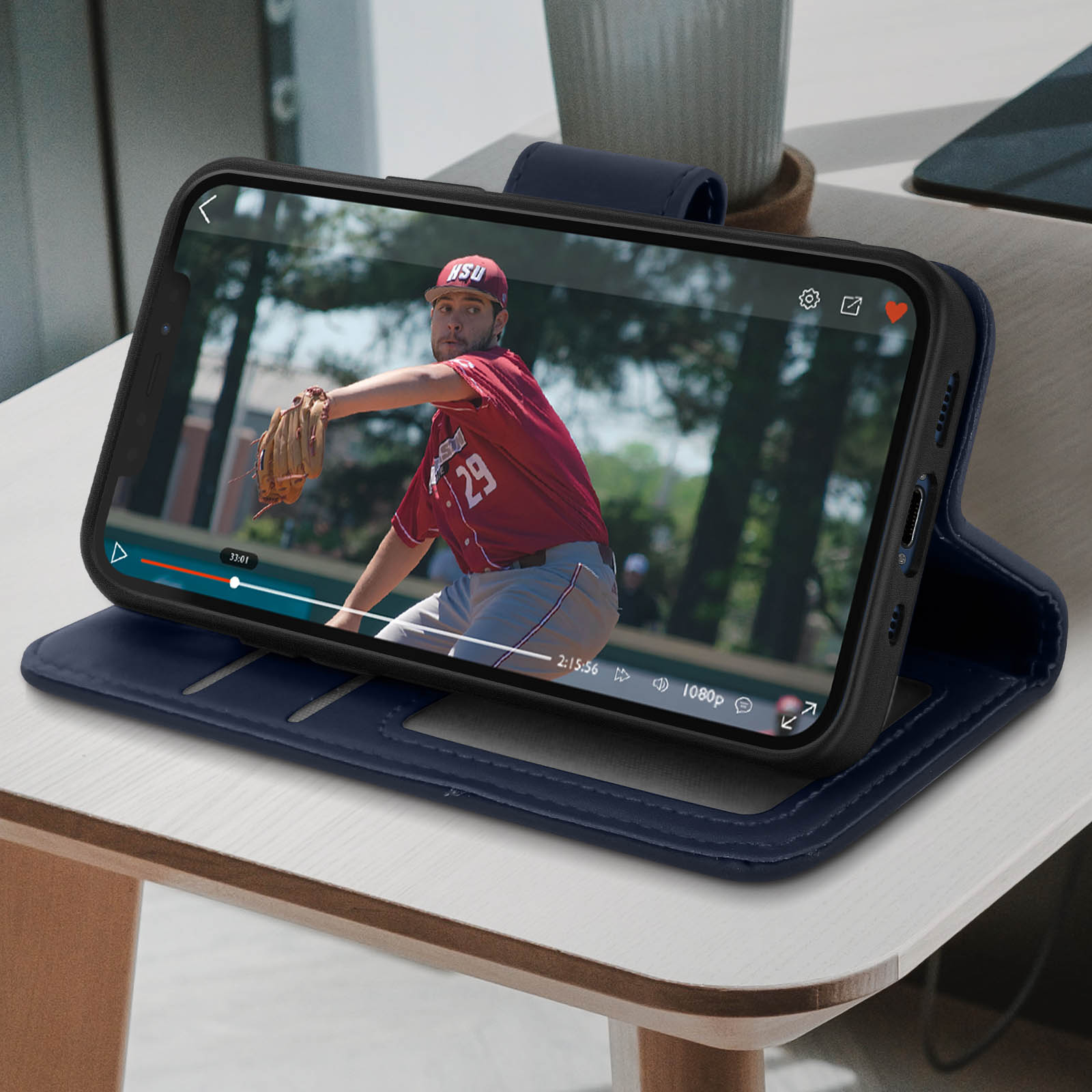 Un telefono in una custodia blu sta riproducendo un video di una partita di baseball su un tavolo.