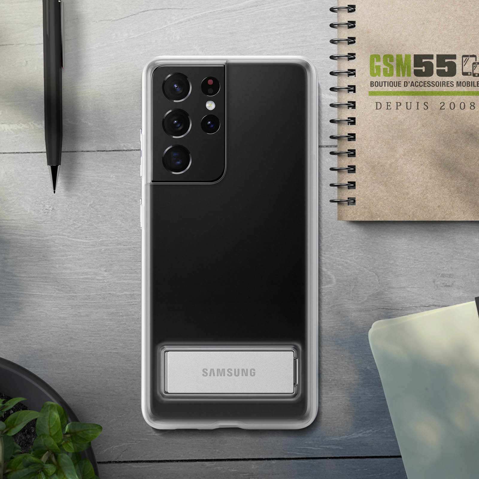 Custodia per telefono sulla scrivania. Un telefono è dentro, con logo Samsung e penna.