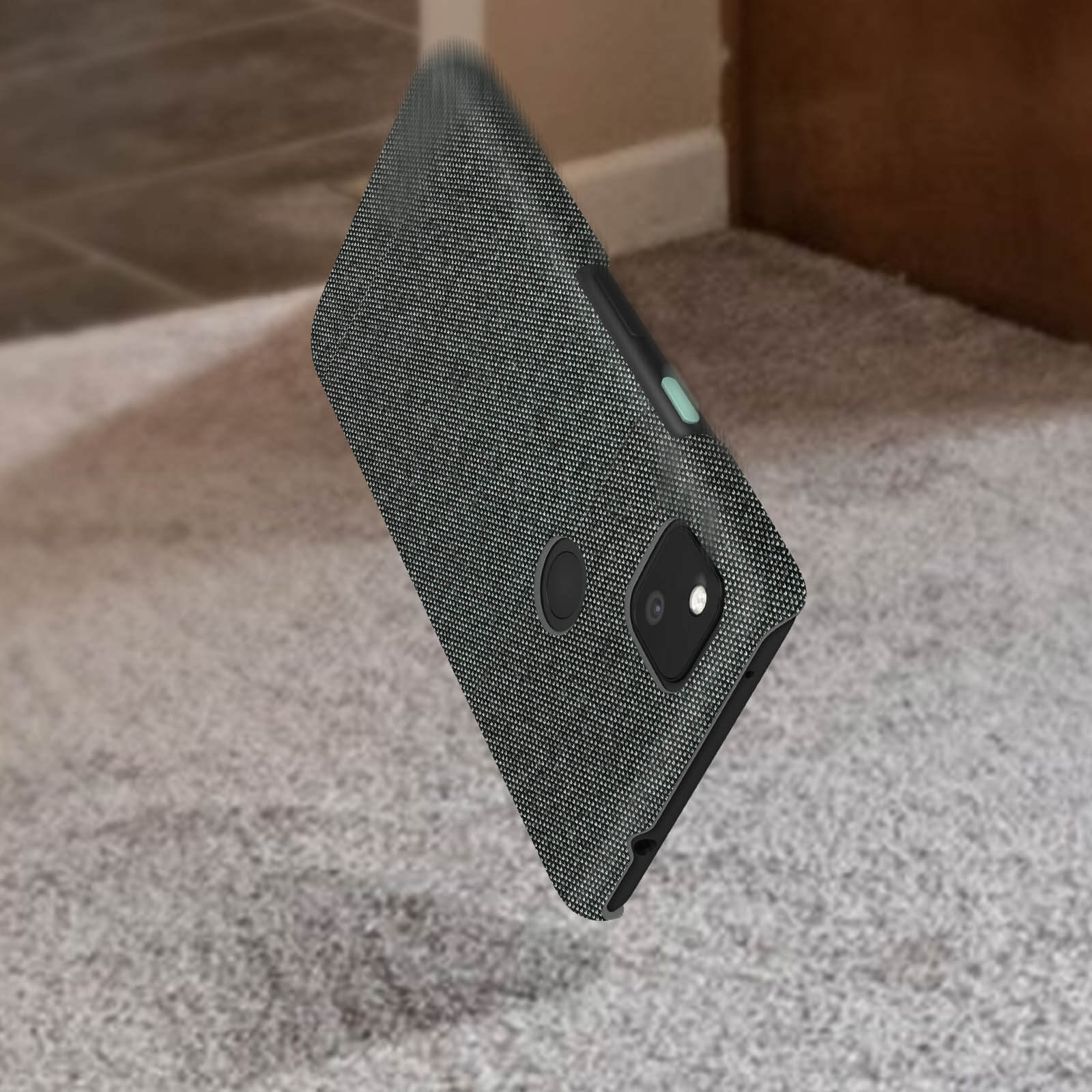 Zwarte telefoonhoes valt, met een telefoon erin. Tapijt en muur op de achtergrond.