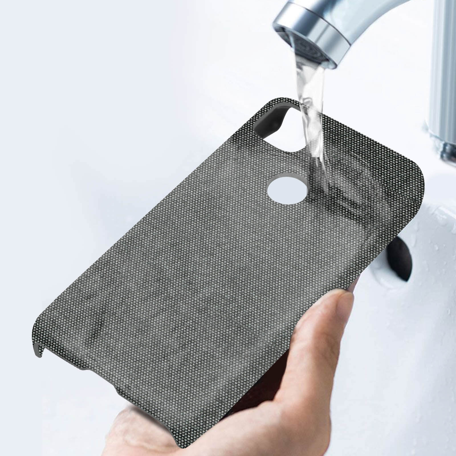 Een telefoonhoesje onder stromend water, met een witte kraan op de achtergrond.