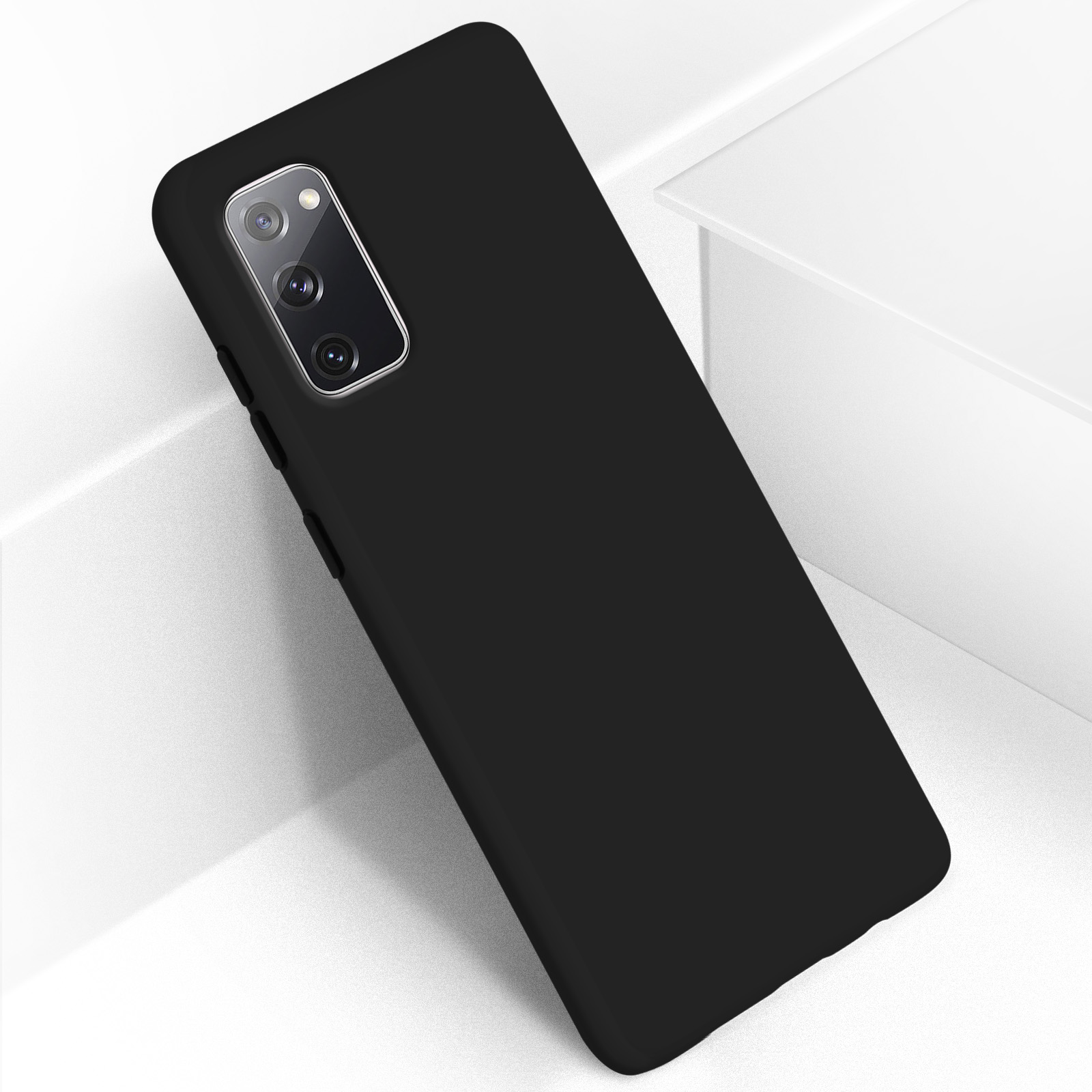 Zwarte telefoonhoes op een wit oppervlak. De telefoonhoes heeft een uitsparing voor de camera en een gladde afwerking.