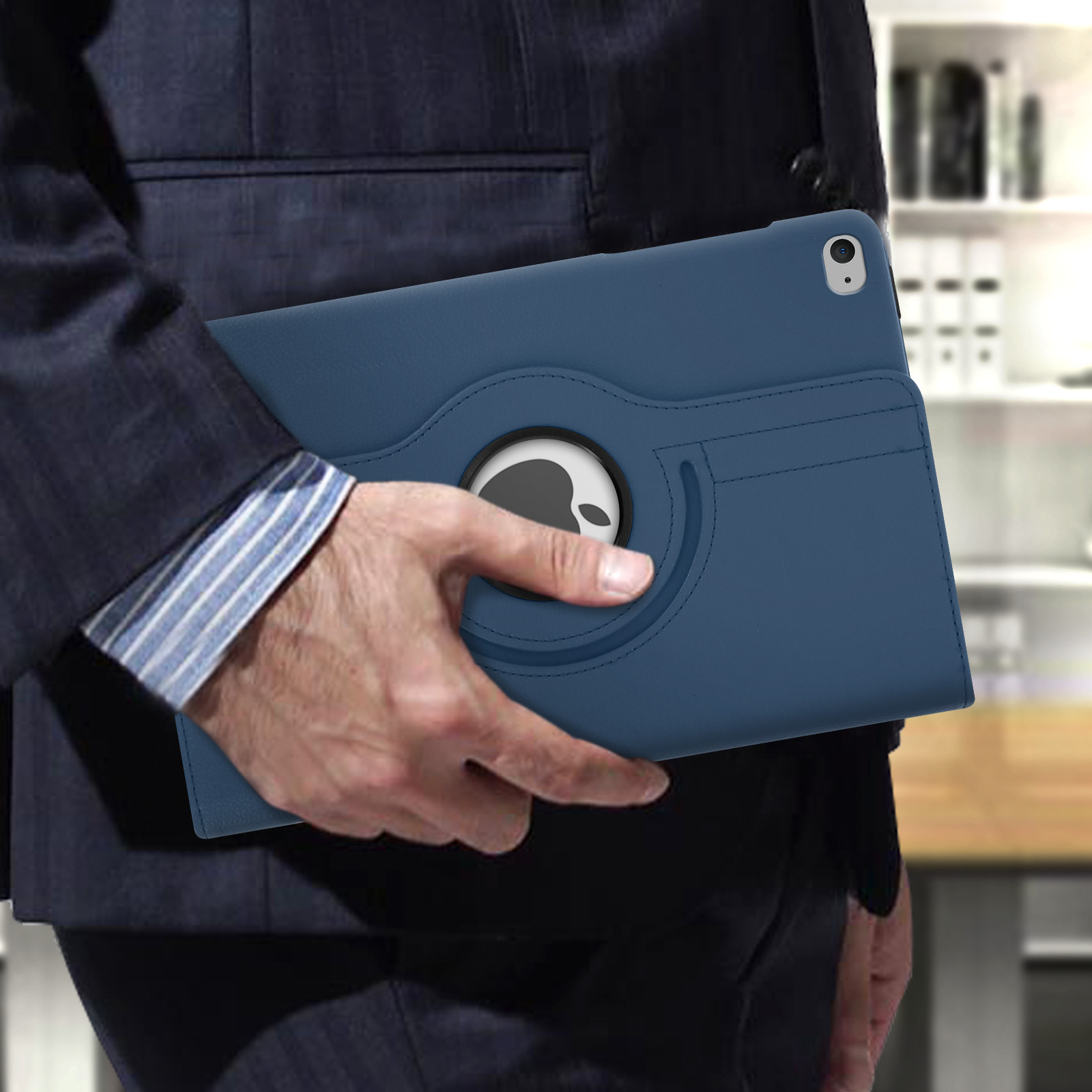 Uomo in giacca e cravatta che tiene una custodia blu per tablet con supporto rotante. Il logo Apple è visibile.