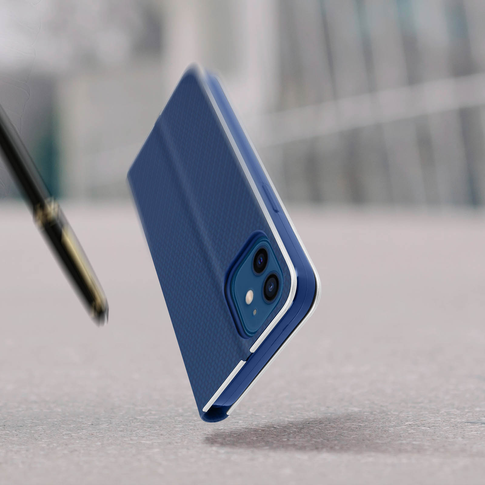 Custodia per telefono con design blu su un tavolo, con una penna sfocata in primo piano.