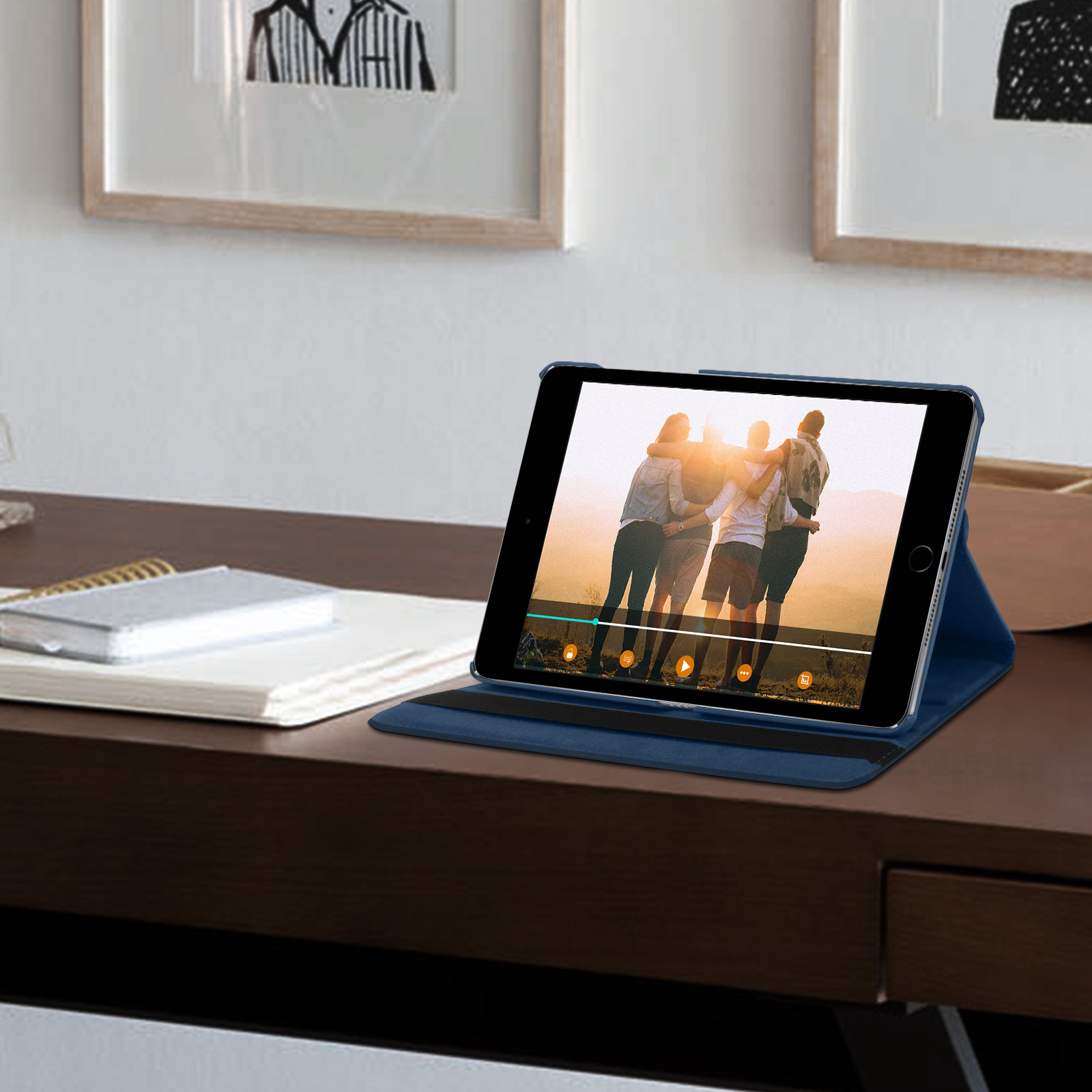 Tablet su una scrivania che mostra un video di persone. Circondato da altri oggetti.