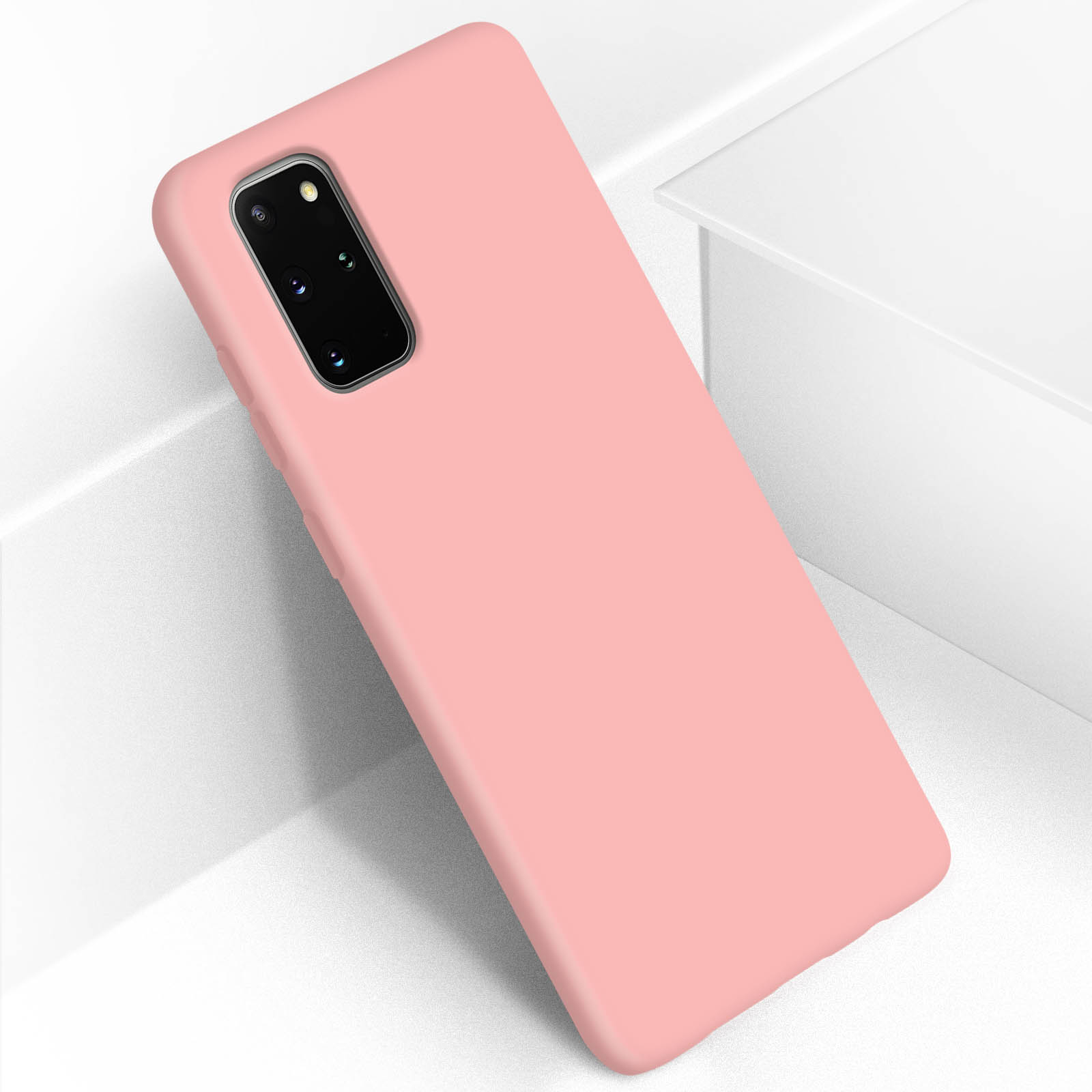 Een roze telefoonhoes leunt tegen een wit oppervlak. De hoes is effen van kleur en heeft een uitsparing voor de camera.