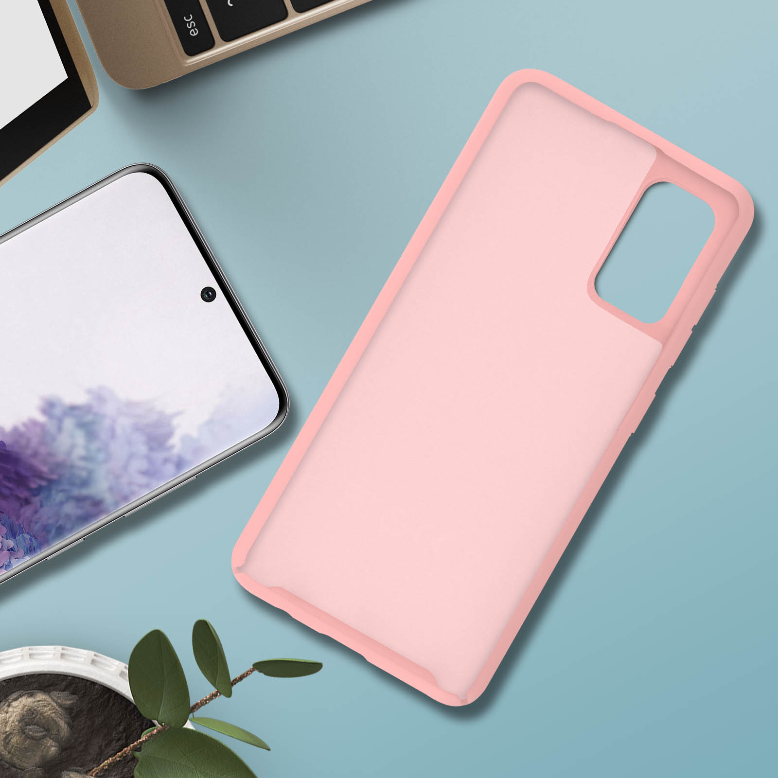 Telefoonhoesje is roze, ligt op een tafel, naast de telefoon. Telefoon is zwart.