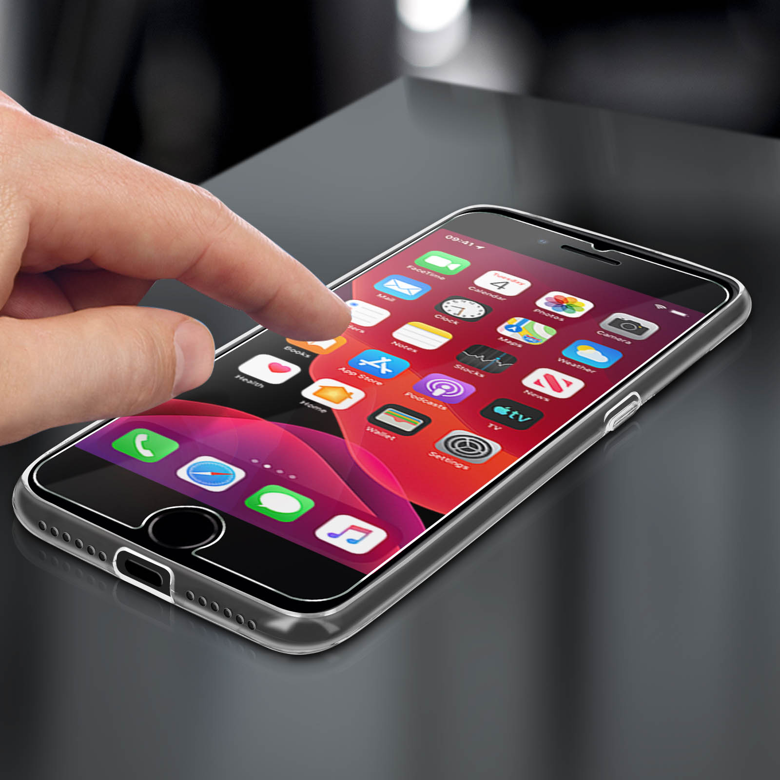 Una mano tocca lo schermo di un telefono. Il telefono è su una superficie nera.
