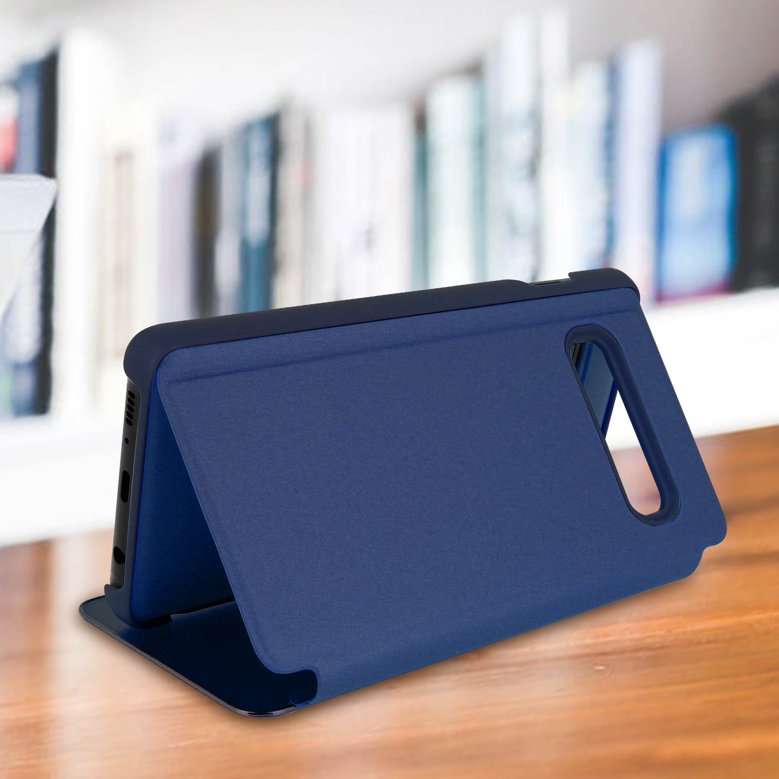 Custodia blu per telefono con cover a ribalta, aperta su superficie in legno, libreria sfocata sullo sfondo.