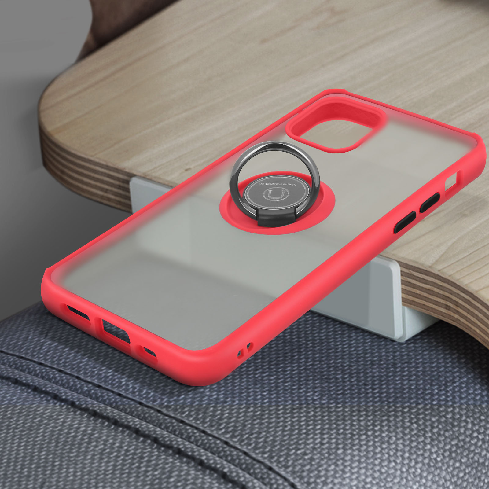 Custodia rossa con anello di supporto. Superficie in legno e sfondo in denim.