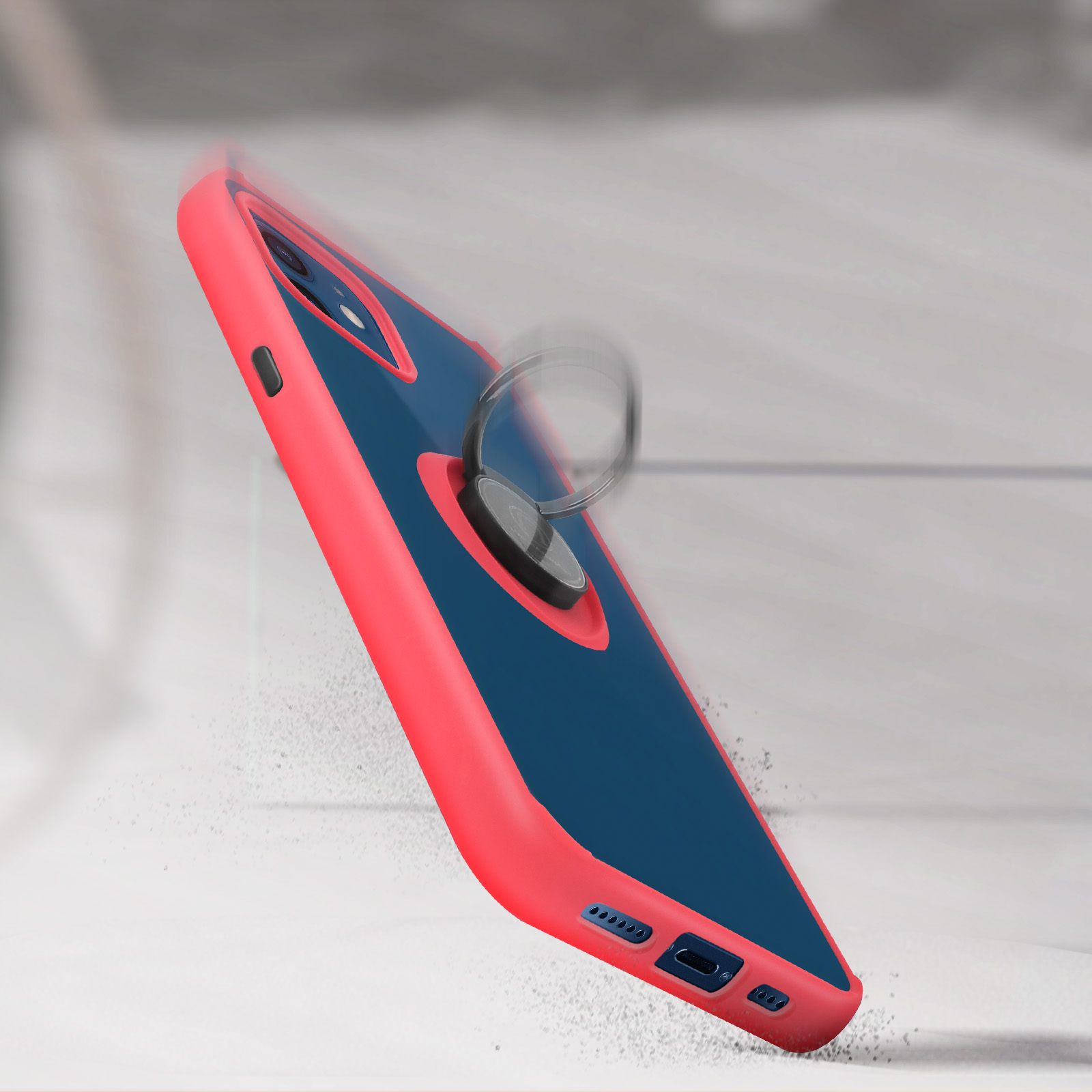 Una custodia per telefono rossa e blu con un anello. La custodia sta cadendo. Lo sfondo è sfocato.