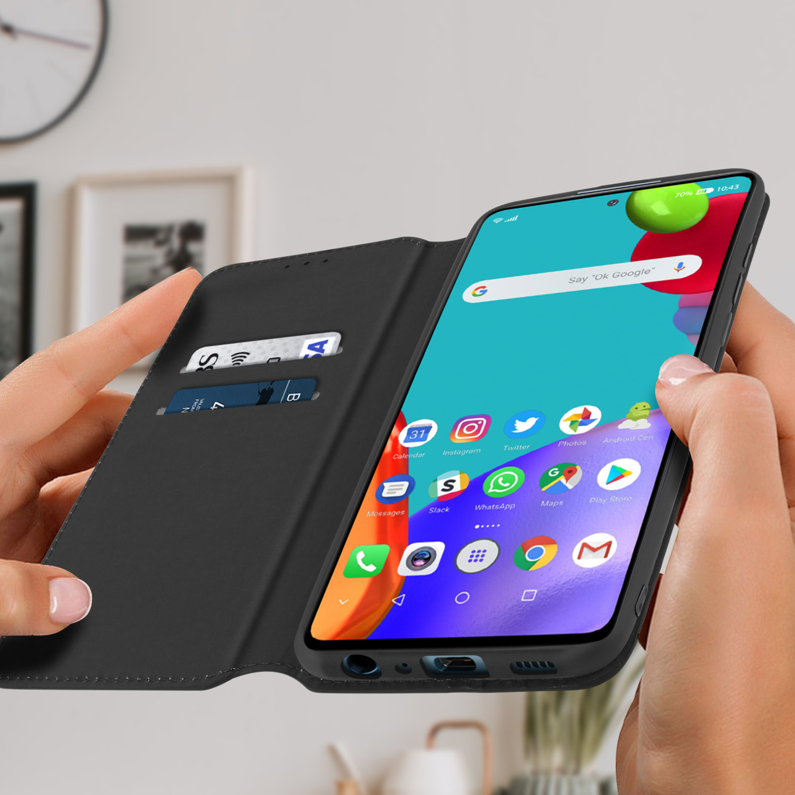 Mani che tengono un telefono in una custodia nera aperta, che mostra uno schermo di app colorate.