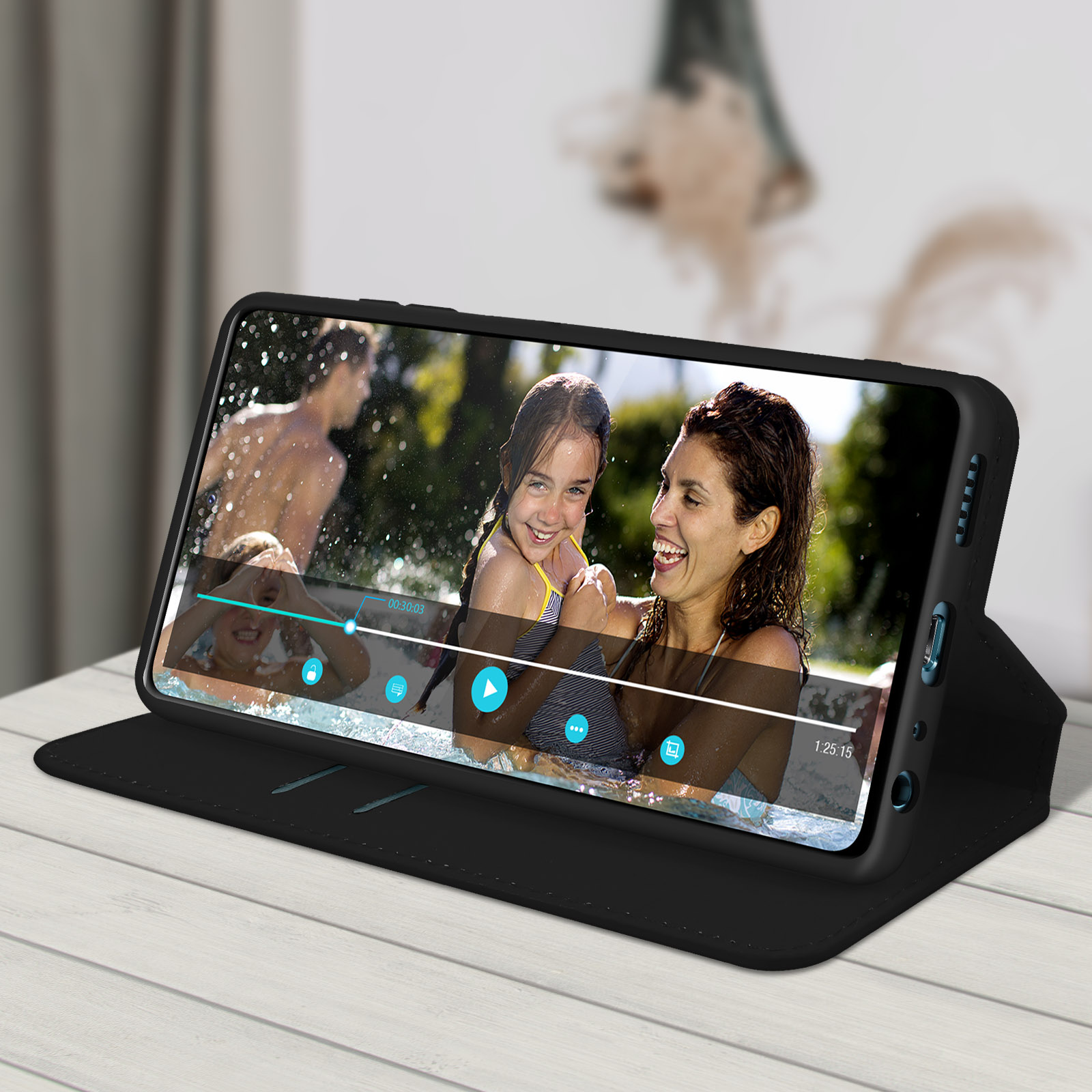 Un telefono mostra un video di persone in piscina. Il telefono è in una custodia nera.