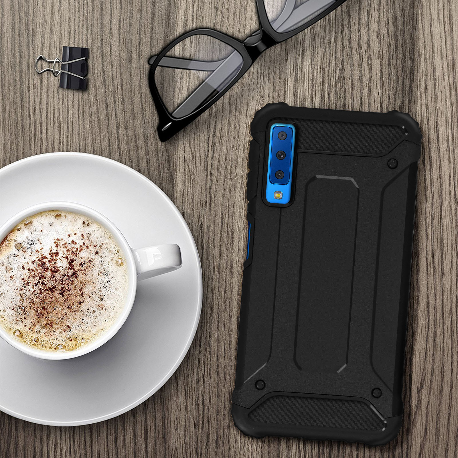 Schwarze Handyhülle mit einer Kaffeetasse und Brille. Holztisch.