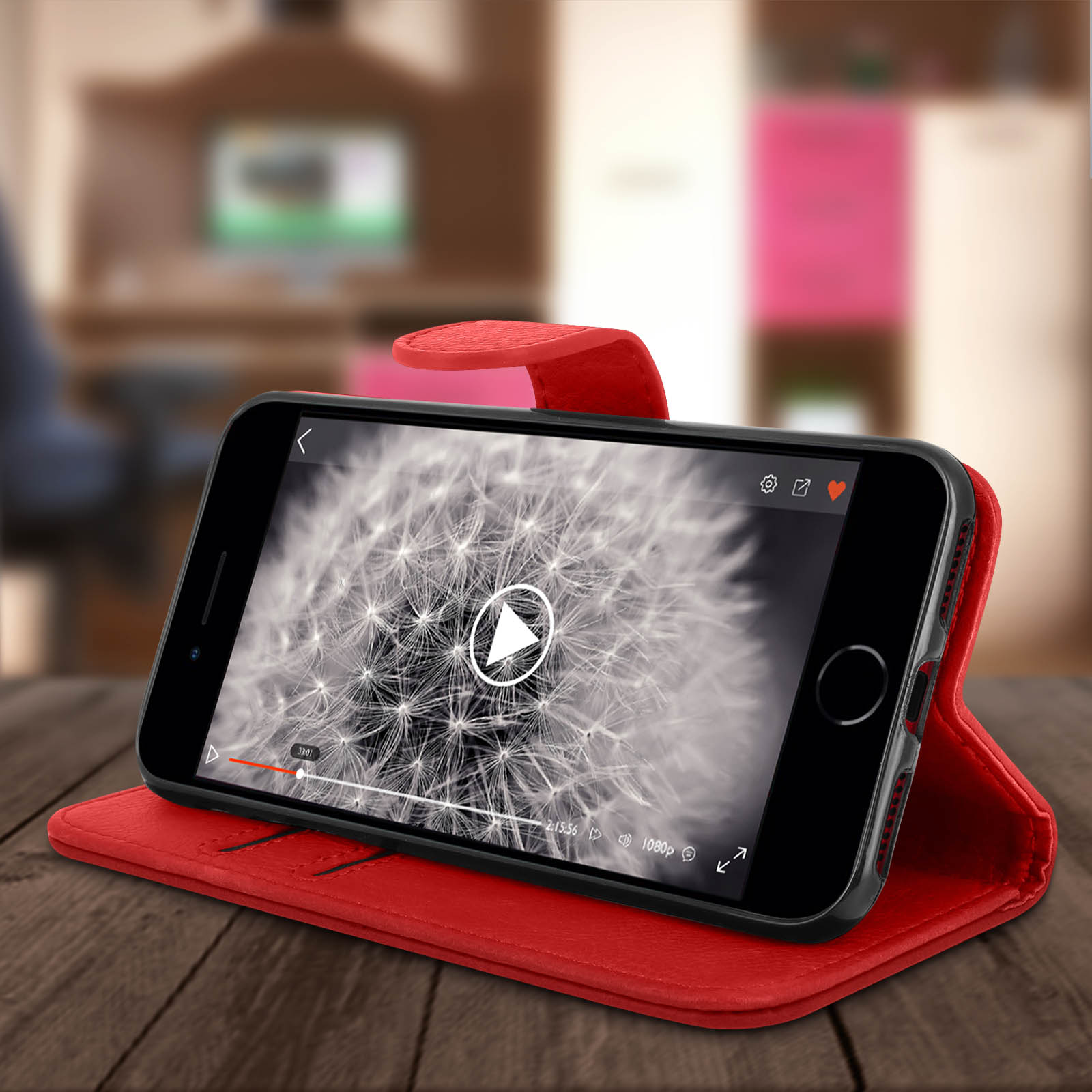 Telefono che riproduce un video su una custodia rossa. La custodia è aperta, su una superficie di legno. Sfondo sfocato, con una stanza.