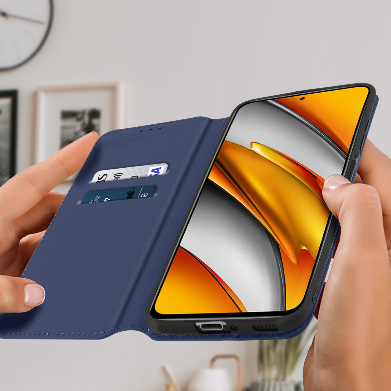 Handen houden een blauwe telefoonhoes vast met een open telefoon, met creditcards zichtbaar.