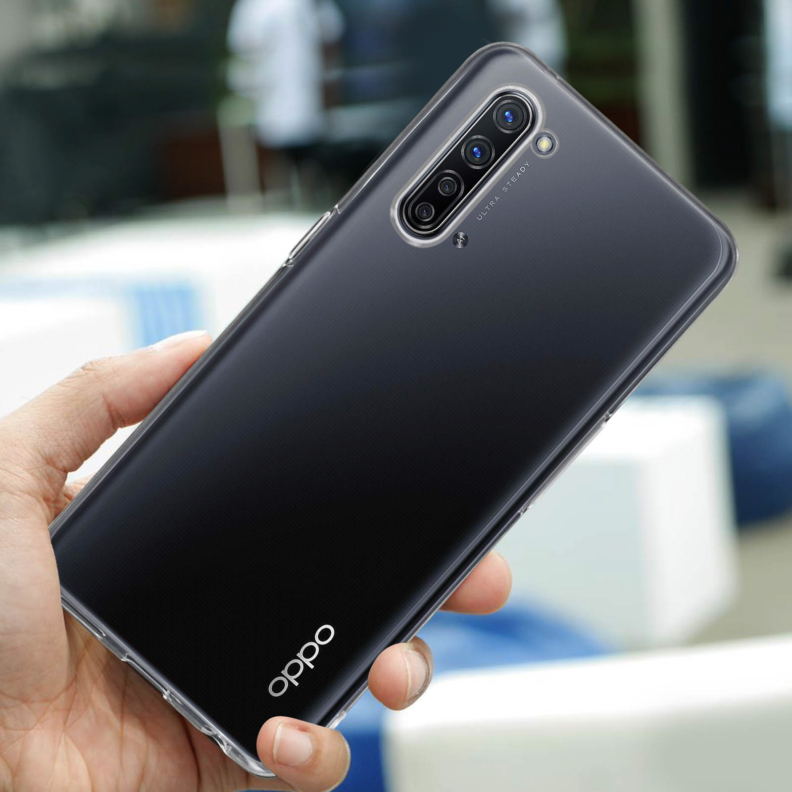 Mano che tiene una custodia trasparente. Il telefono ha tre fotocamere e il logo Oppo.