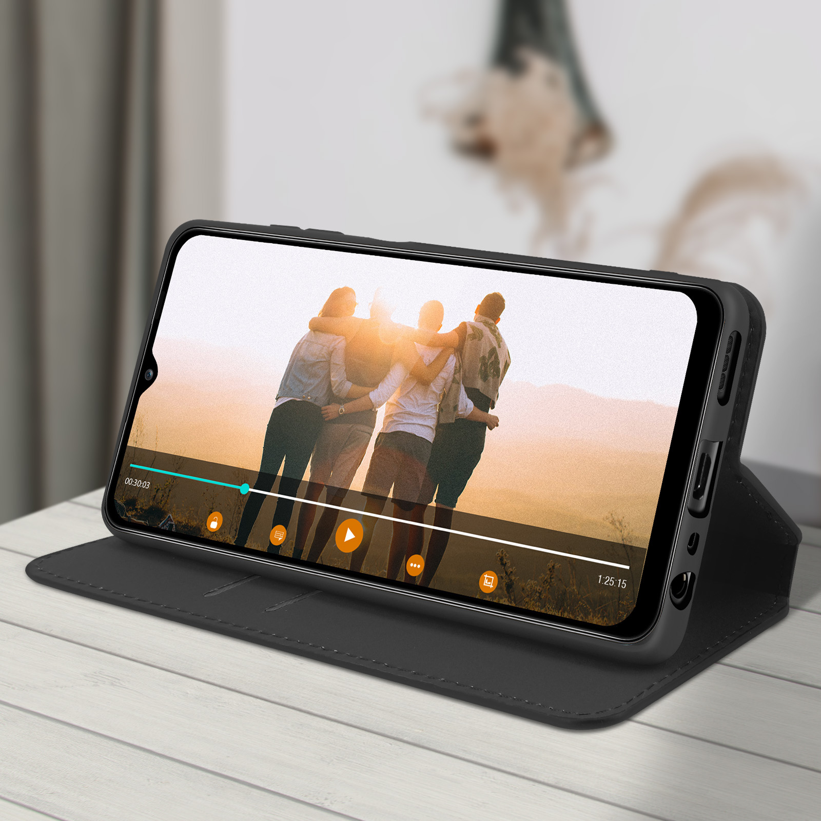 Telefono in custodia nera che mostra un video. Tre persone si abbracciano al tramonto.
