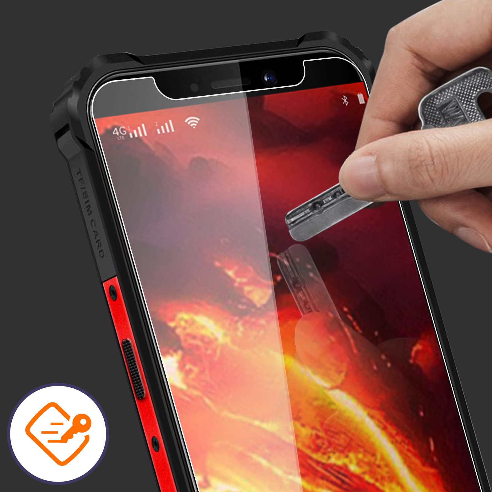 Mano che testa una protezione schermo con una chiave. Telefono in custodia rossa e nera.