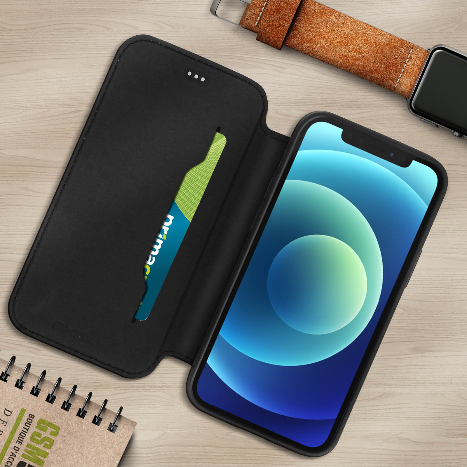 Custodia nera per telefono aperta, con telefono e fessura per carte. Sfondo in legno.