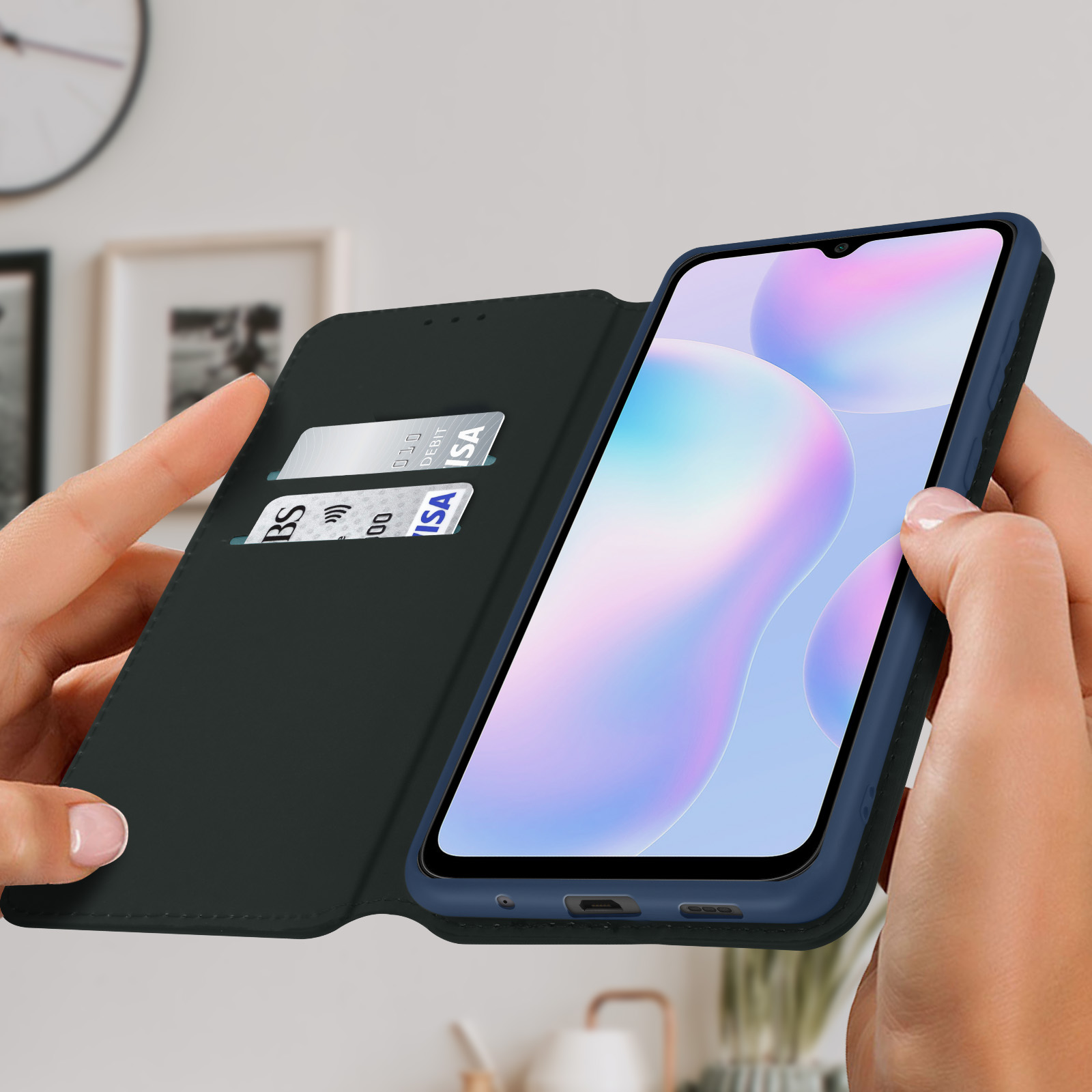 Un telefono in una custodia blu, con carte di credito all'interno. Il telefono è tenuto in mano.