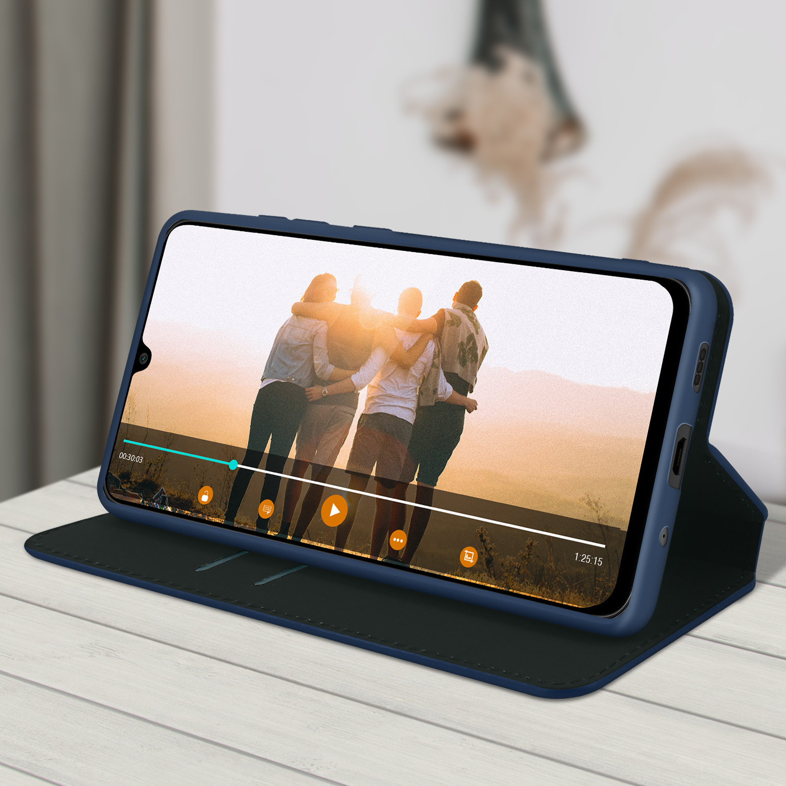 Telefono in custodia su superficie di legno, mostra un video. Persone che si abbracciano sullo schermo.
