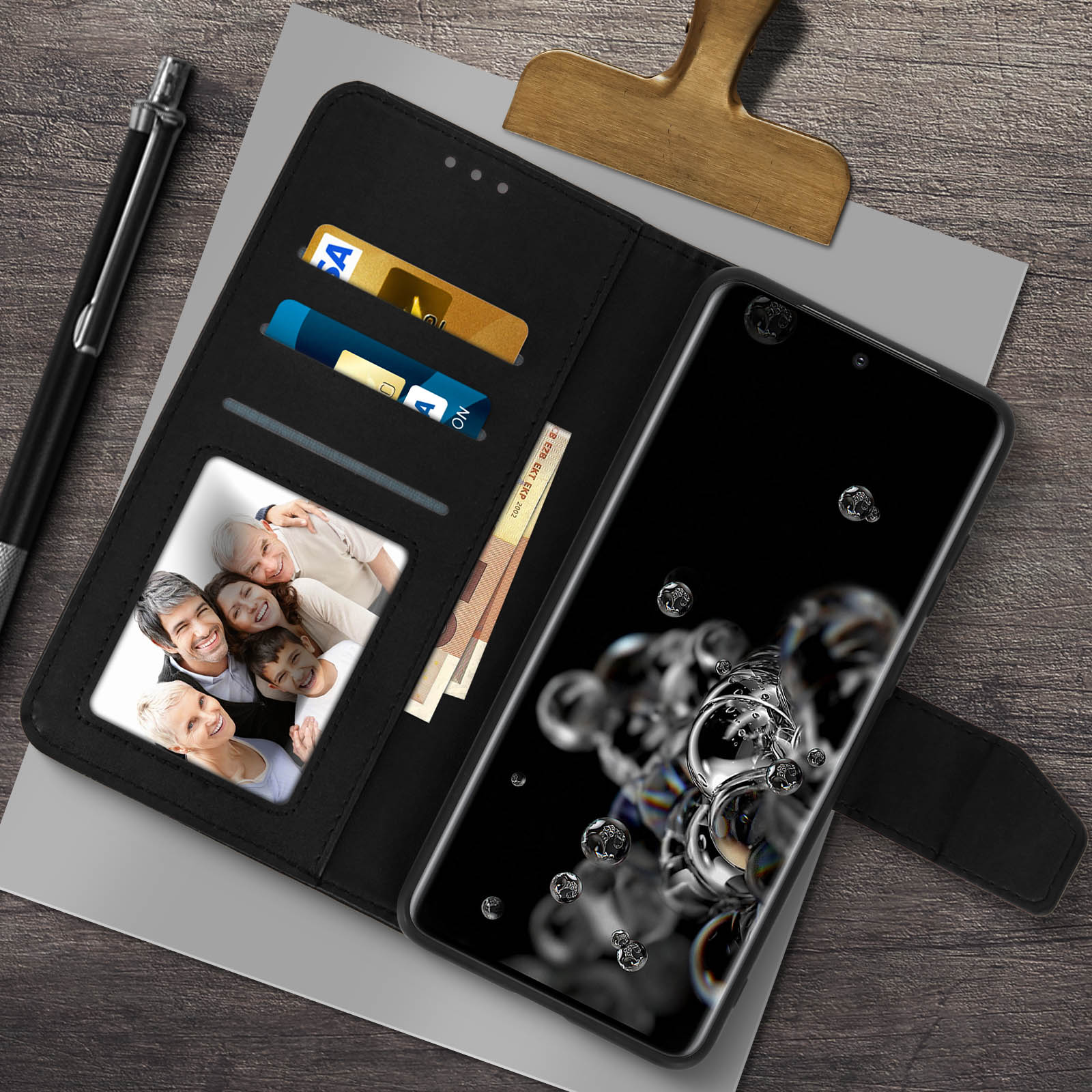 Telefono nero in una custodia a portafoglio nera, che mostra una foto di famiglia e denaro.