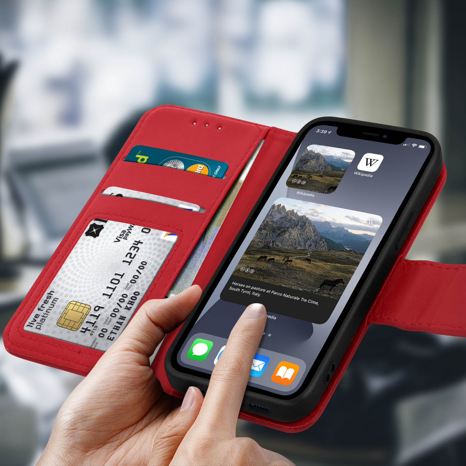 Custodia rossa per telefono con un telefono all'interno. Ha scomparti per carte e uno schermo che mostra una pagina web. Un dito lo tocca.