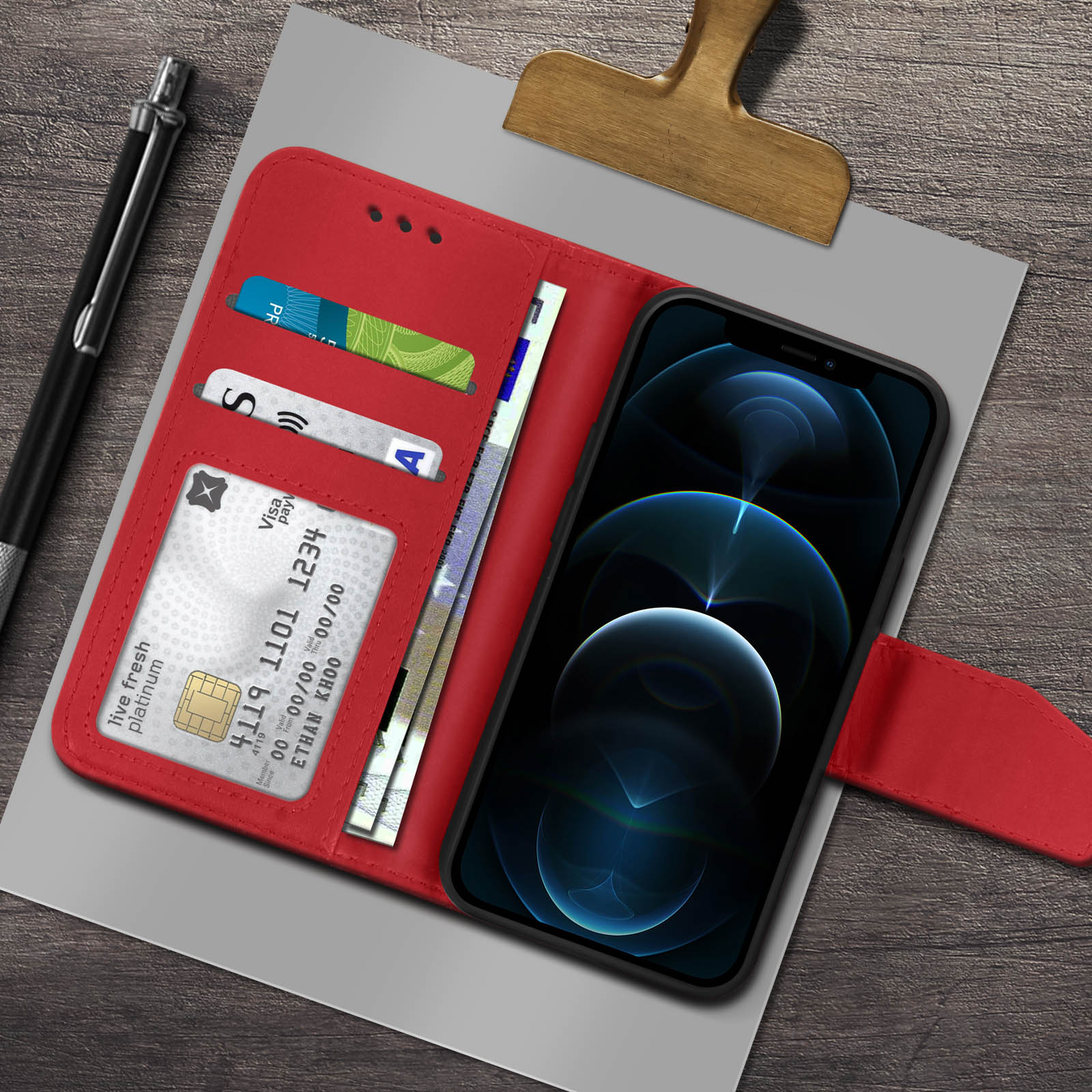 Custodia rossa con carte di credito e smartphone. Penna e clip di legno vicine.