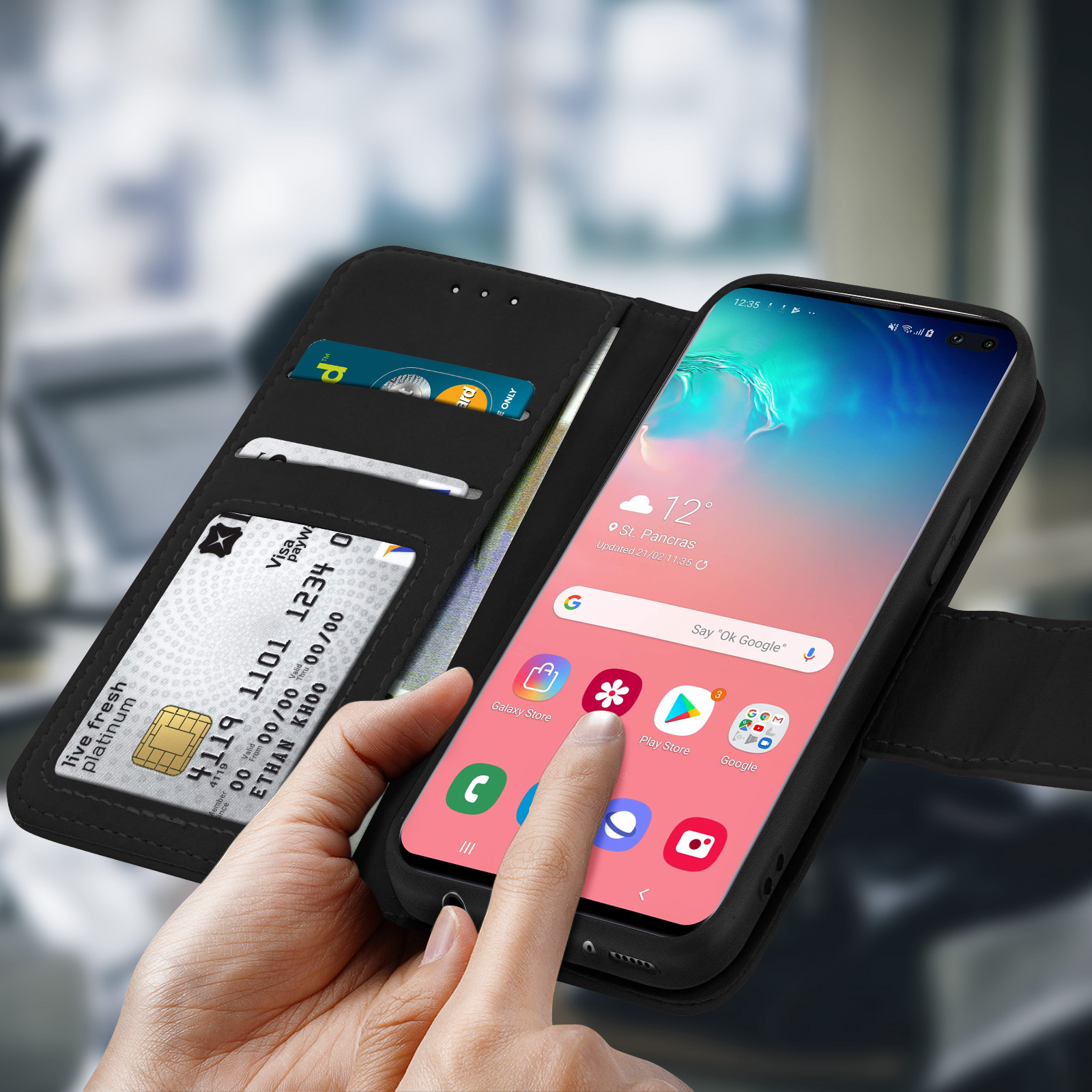 Uno smartphone con una custodia per carte di credito aperta, con carte di credito all'interno e un dito sullo schermo.