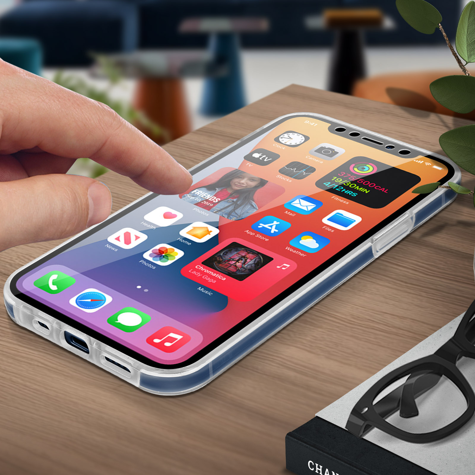 Een telefoon met een hoesje, op een houten tafel. Een hand gebruikt de telefoon. De achtergrond is wazig.