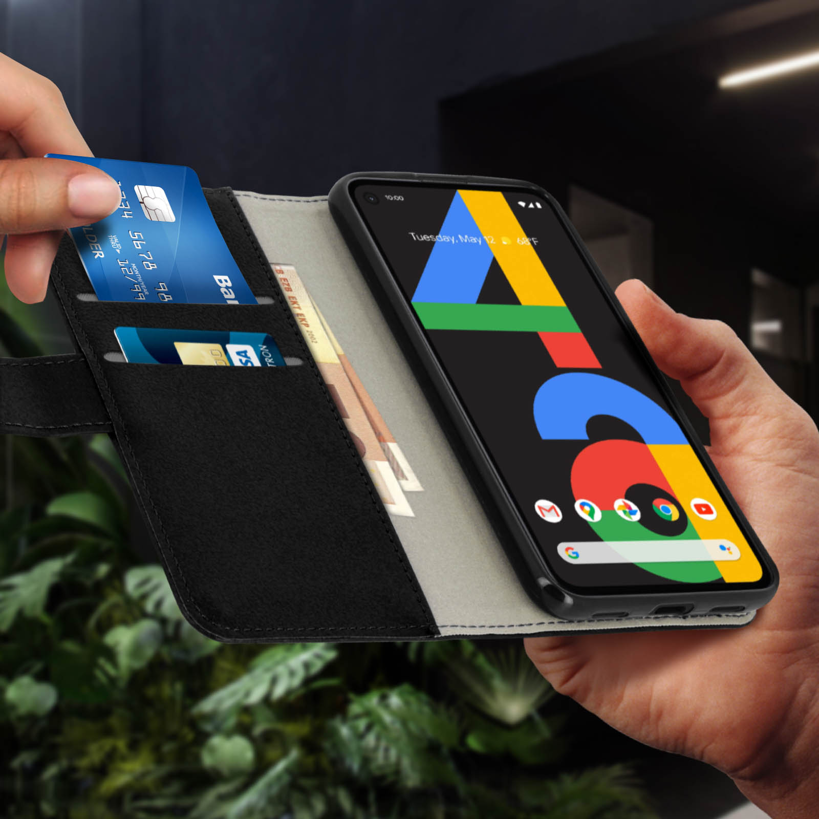 Una persona tiene aperta una custodia per telefono con un telefono dentro. Carte di credito e contanti sono visibili.