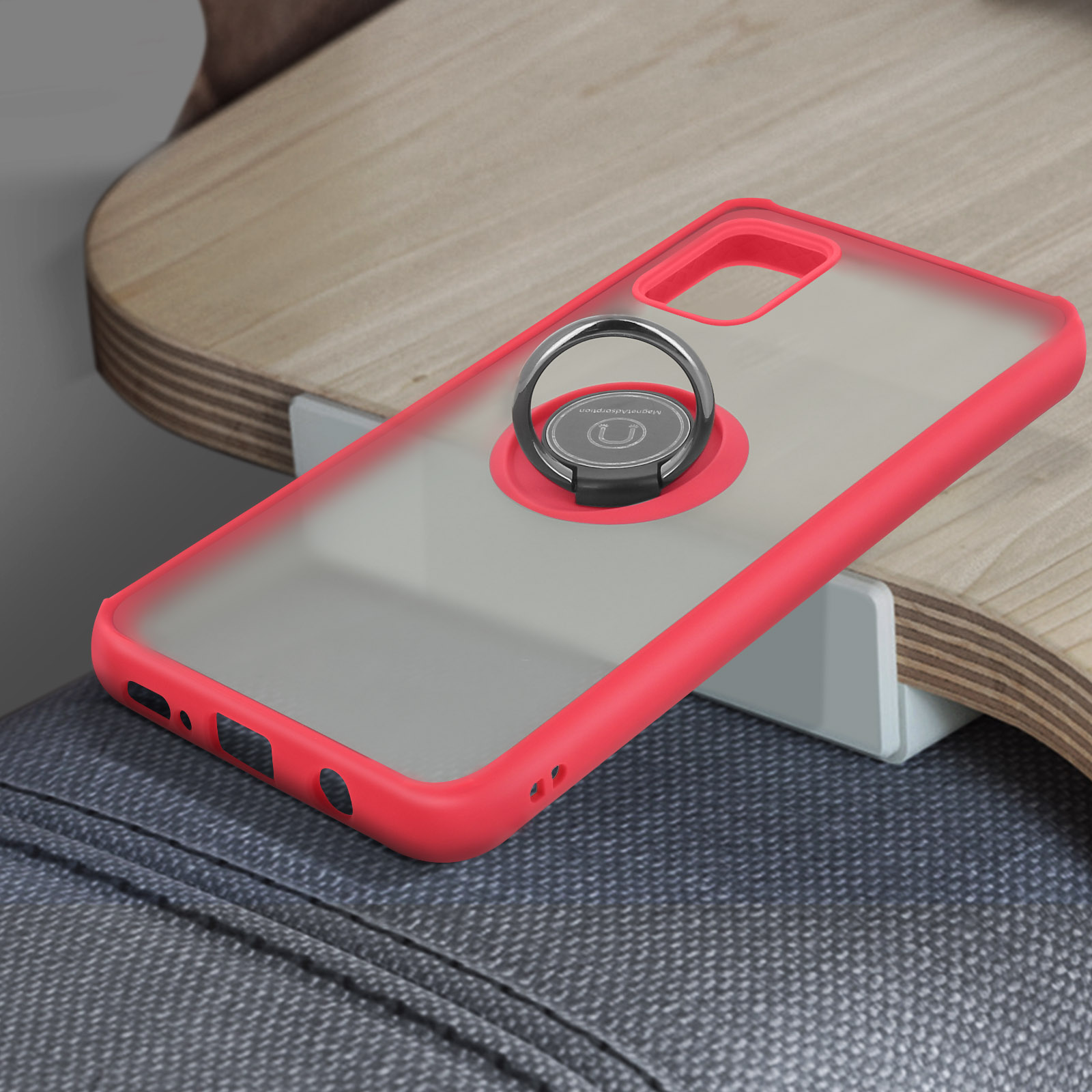 Een rode telefoonhoes met ringhouder, op een houten oppervlak.