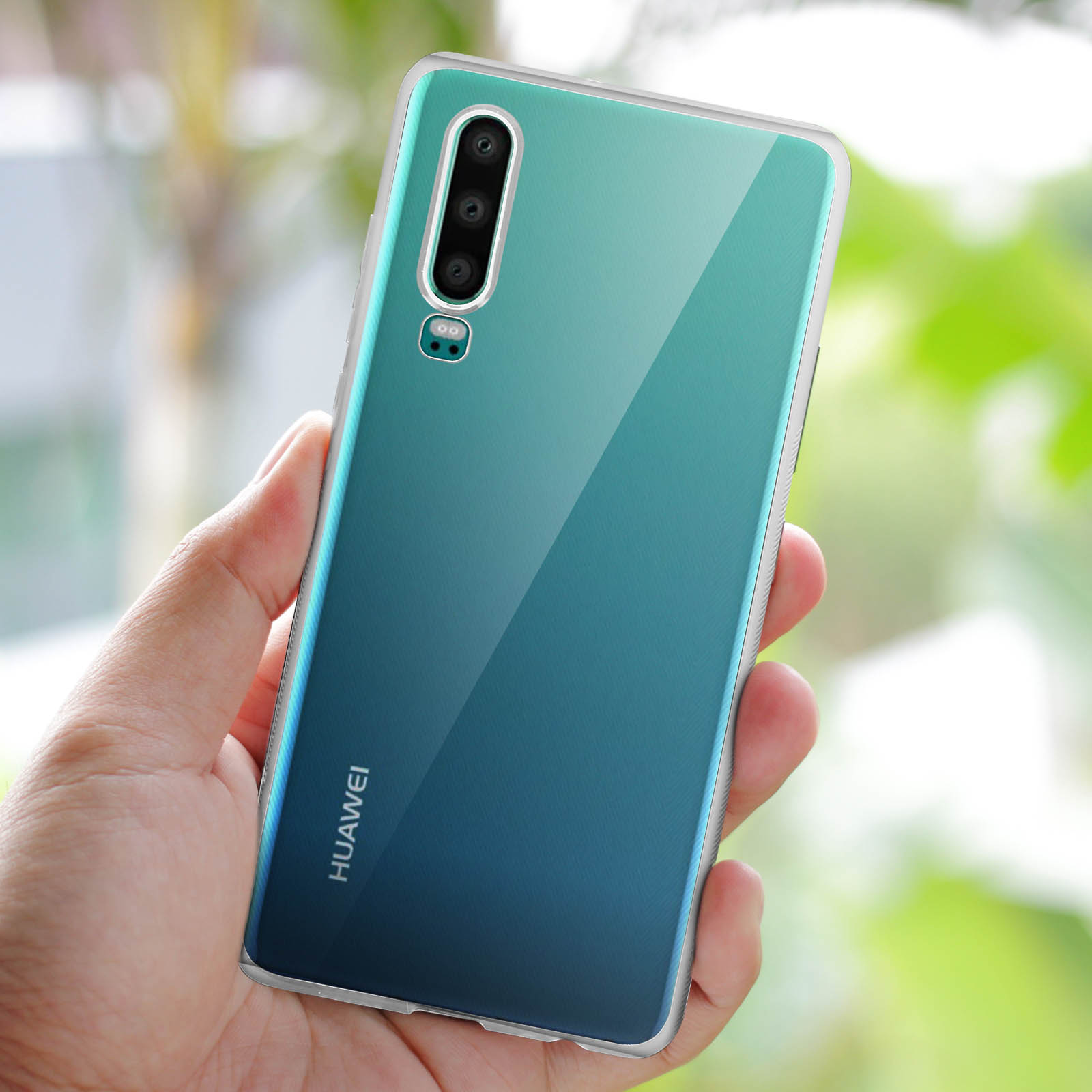 Eine Hand hält ein Telefon mit einem grün-blauen Farbverlauf auf der Rückseite und einer Dreifachkamera.