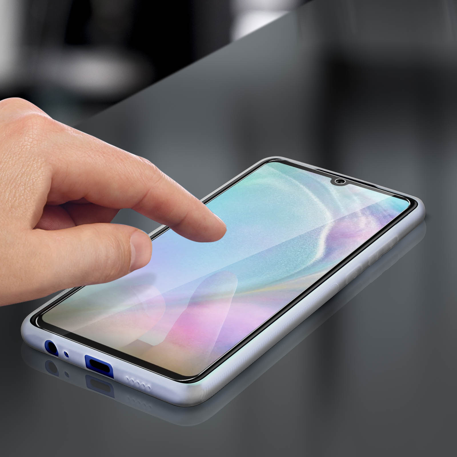 Hand berührt einen Telefonbildschirm. Das Telefon befindet sich in einer Schutzhülle auf einer reflektierenden Oberfläche.
