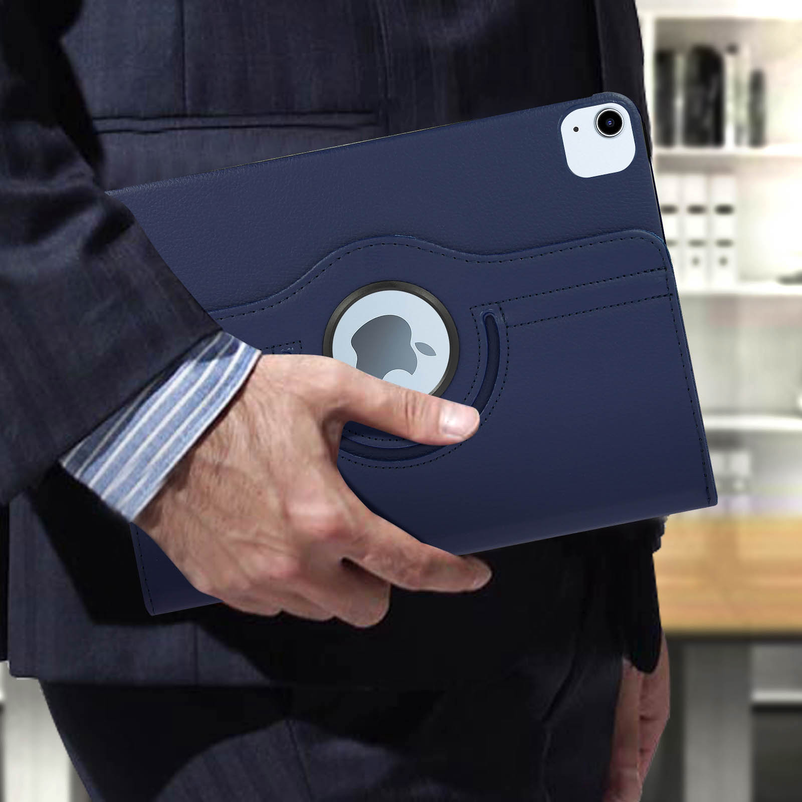 Una persona tiene in mano una custodia blu per tablet. La custodia è aperta, rivelando il logo Apple.
