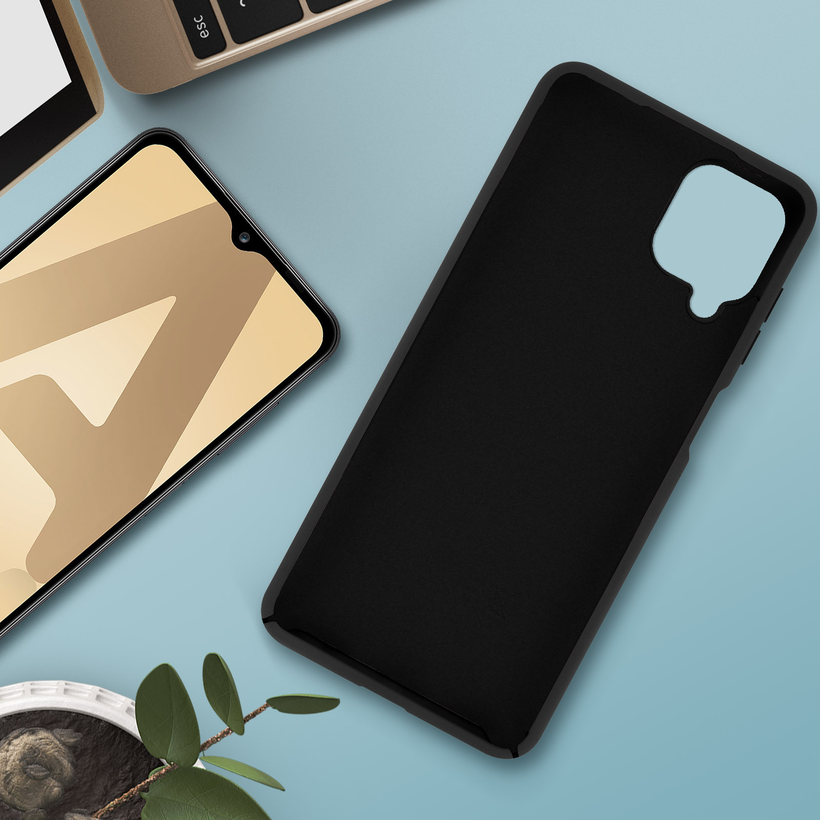Custodia nera per telefono su superficie blu, telefono con schermo beige. Laptop e pianta sullo sfondo.