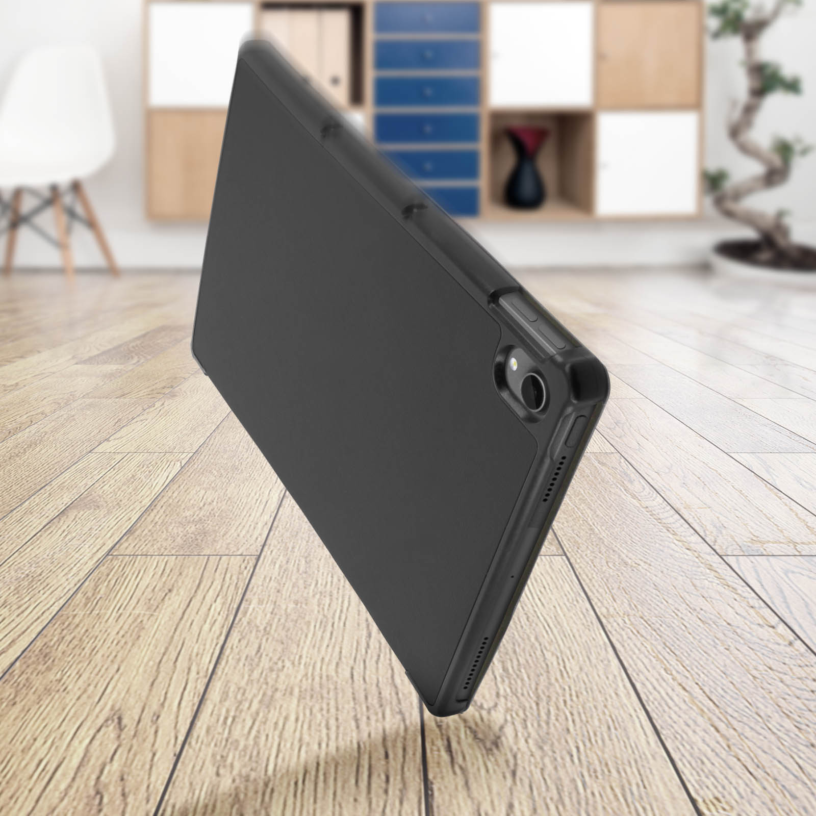 Una custodia per telefono nera su un pavimento in legno, con uno sfondo sfocato che mostra un mobile e decorazioni.