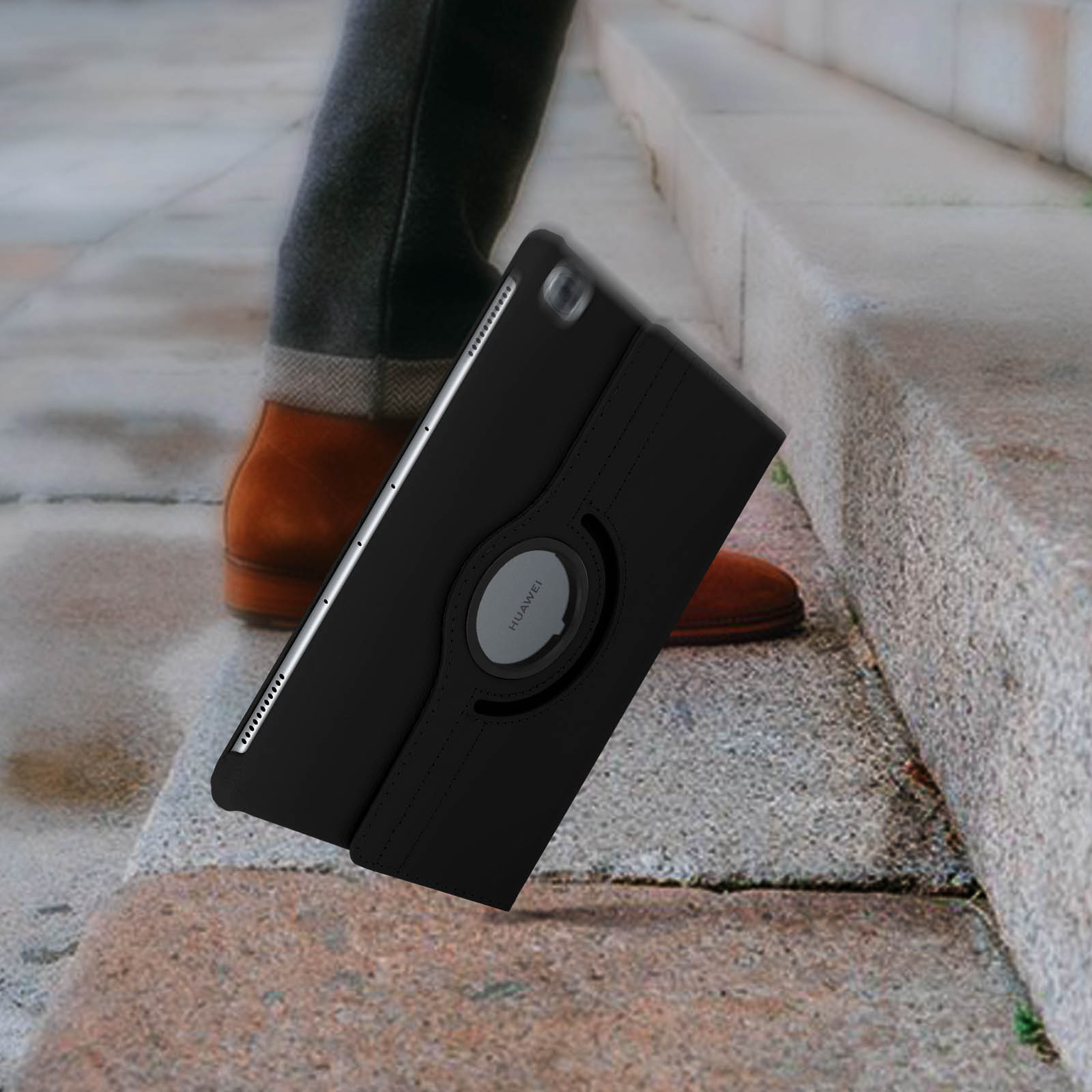 Tablet in una custodia che cade dalle scale. Le gambe di una persona sono visibili.